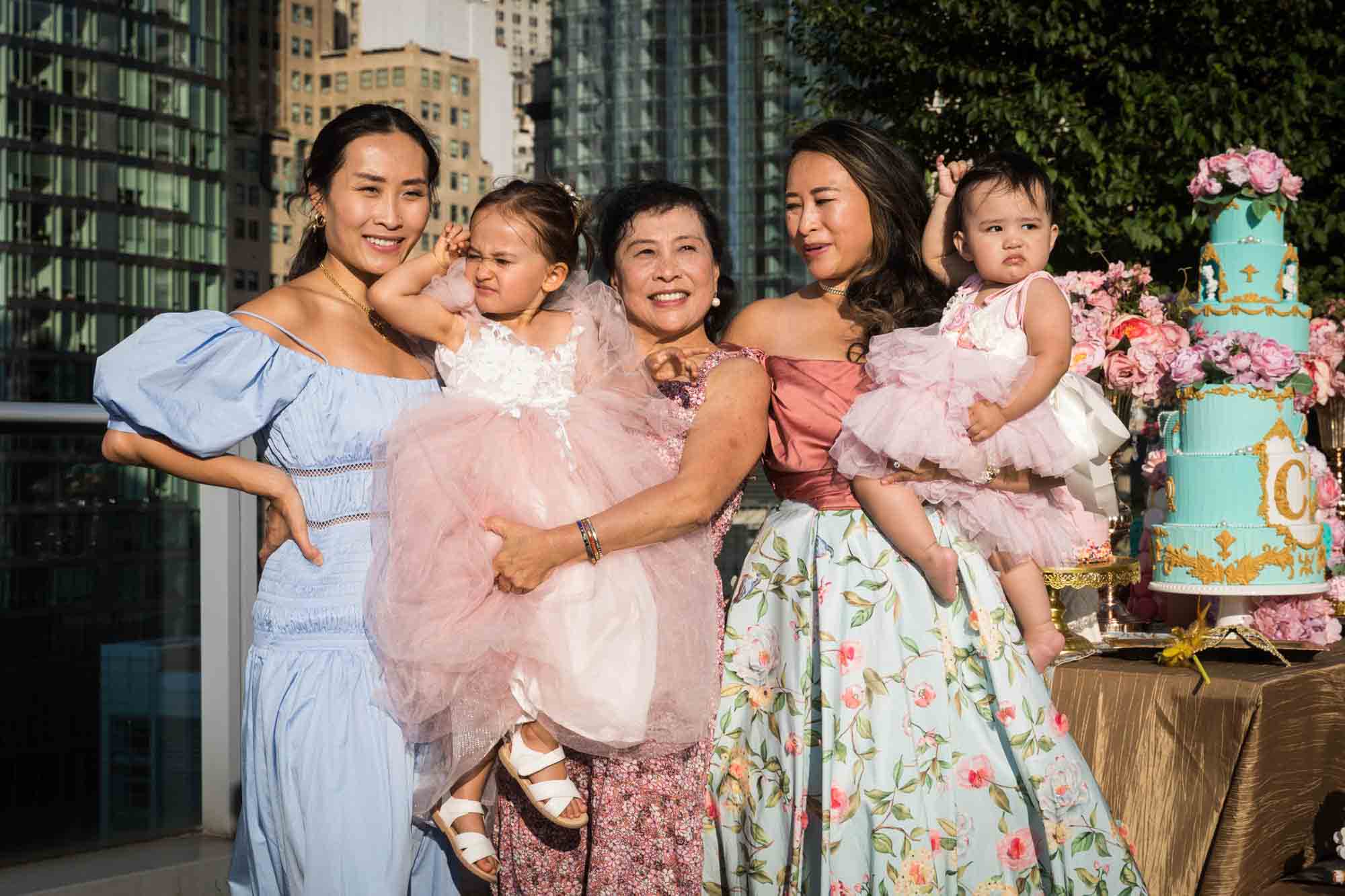 Three women holding two little girls while dressed as French court members for an article on event planning photography tips