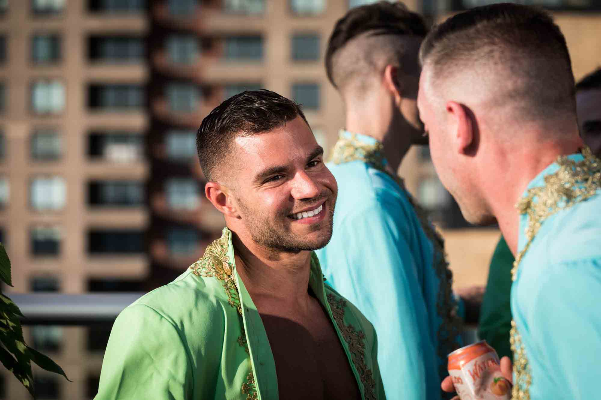 Guest wearing green jacket enjoying a Marie Antoinette-themed party on an outdoor patio in NYC