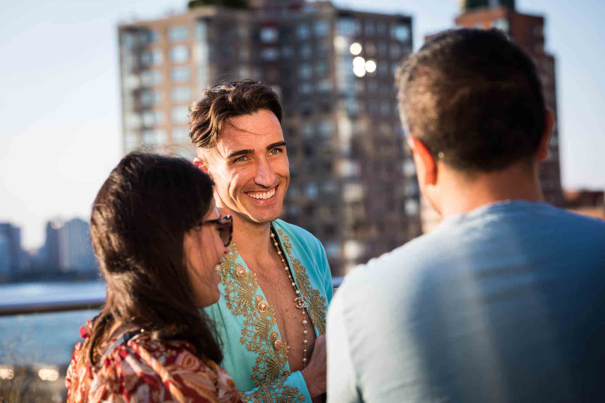 Guests wearing aqua jacket enjoying a Marie Antoinette-themed party on an outdoor patio in NYC