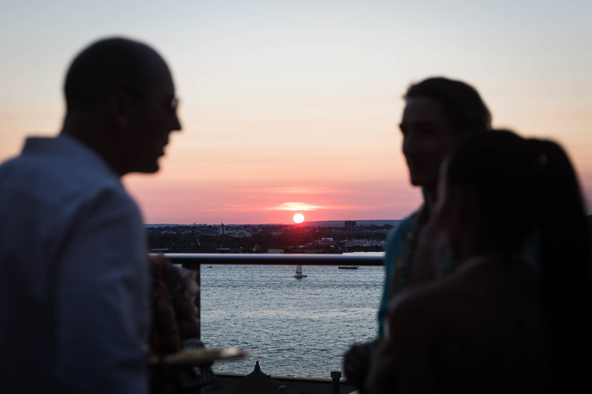 Sunset over the Hudson River behind guests at an outdoor party
