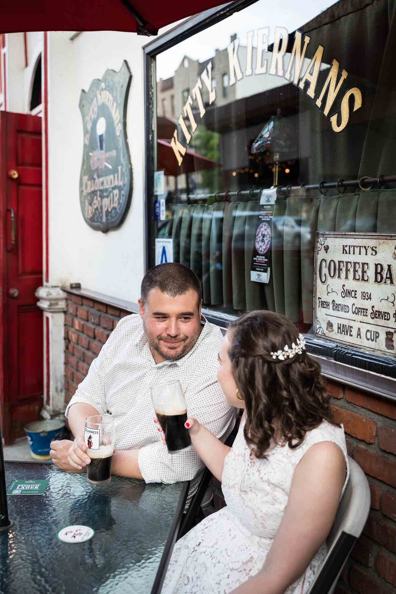 Couple drinking glasses of beer in front of Irish bar for an article on how to recreate your love story in your engagement shoot
