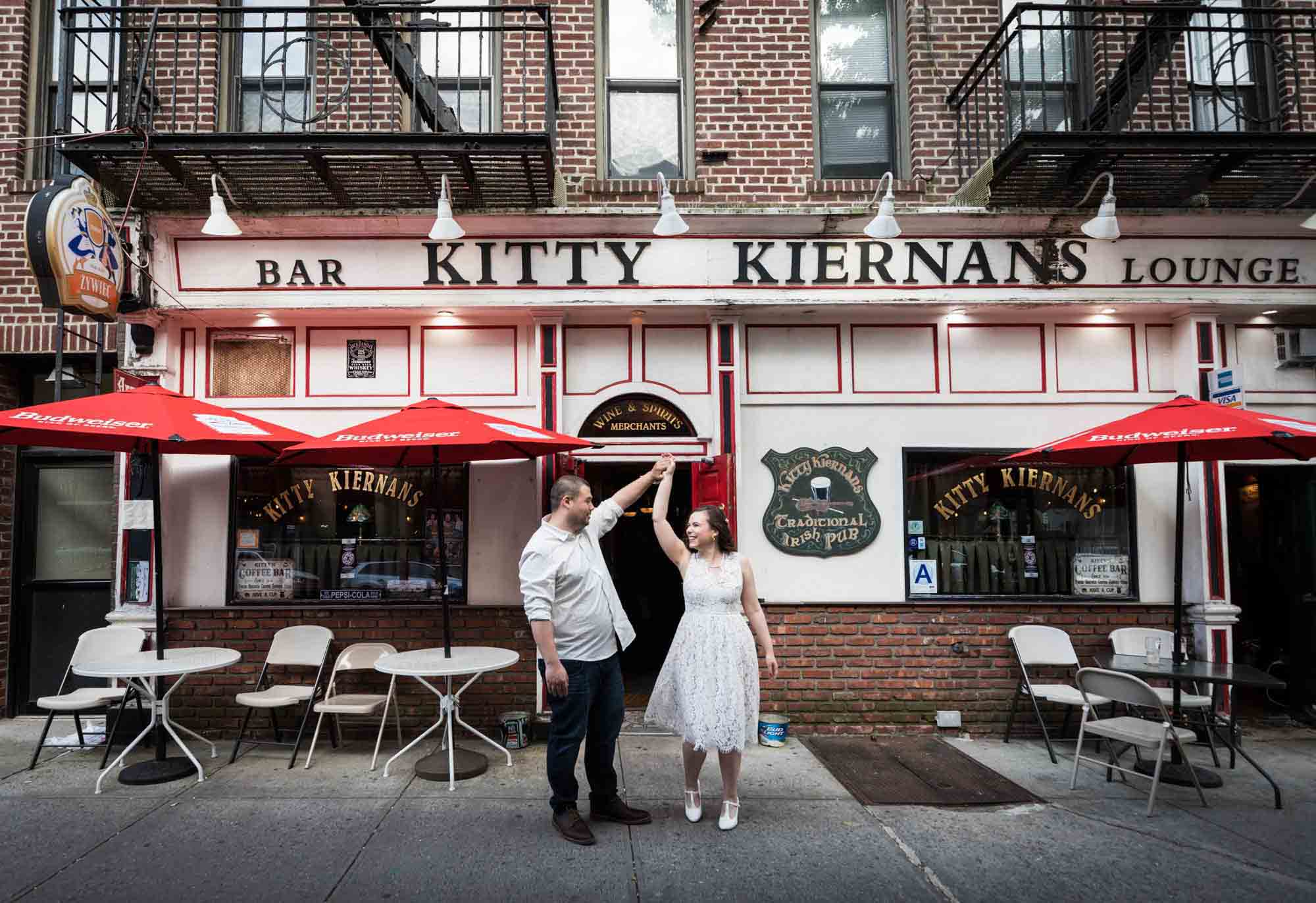Couple dancing on sidewalk in front of Irish bar for an article on how to recreate your love story in your engagement shoot 