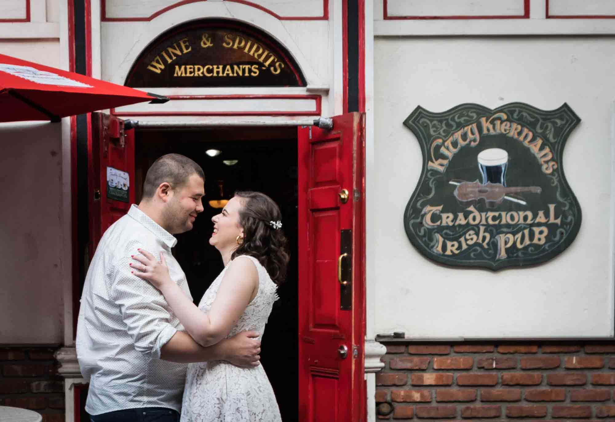 Couple hugging in front of Irish bar during a Bay Ridge engagement shoot