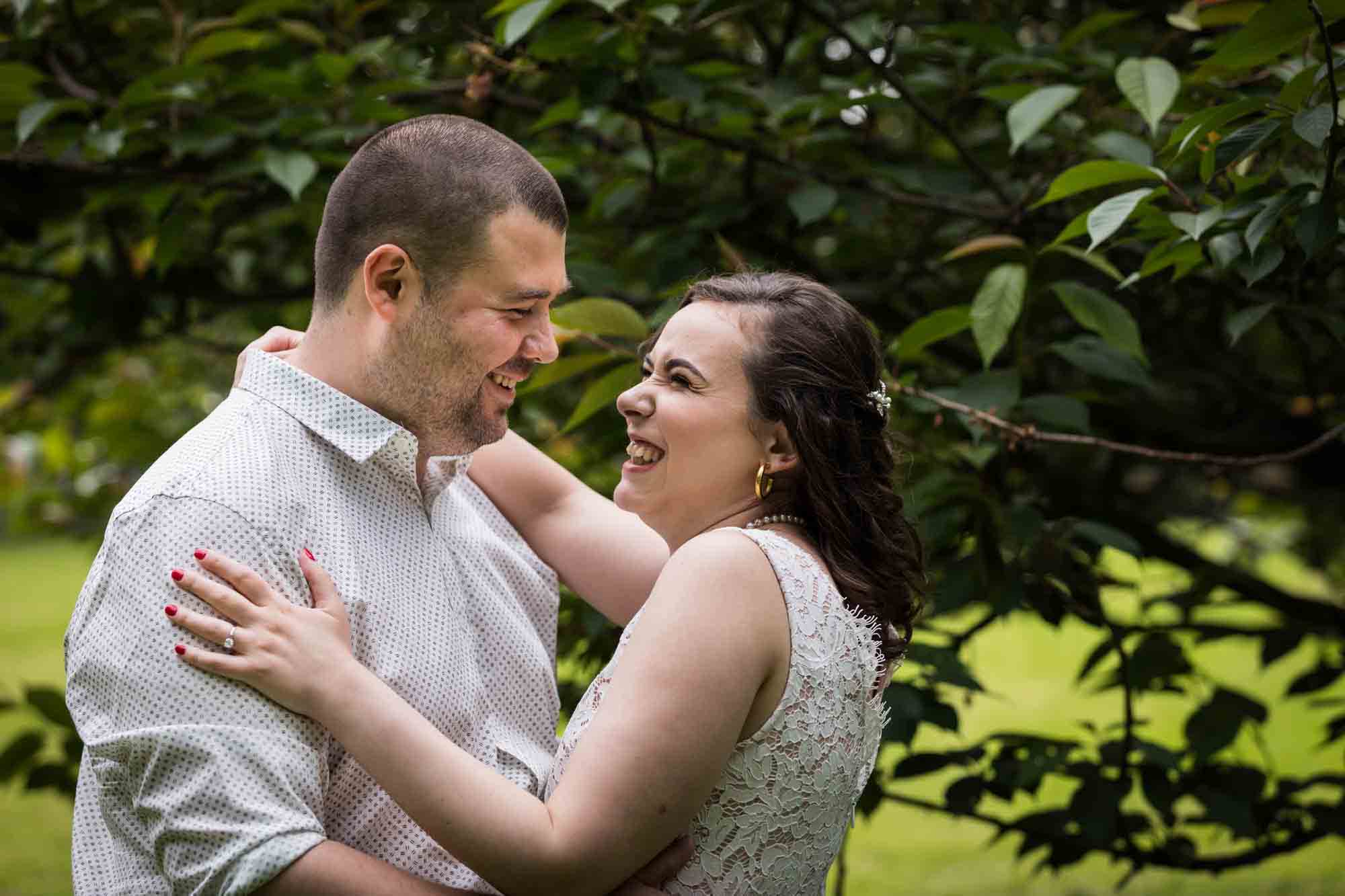 Couple hugging in front of tree for an article on how to recreate your love story in your engagement shoot