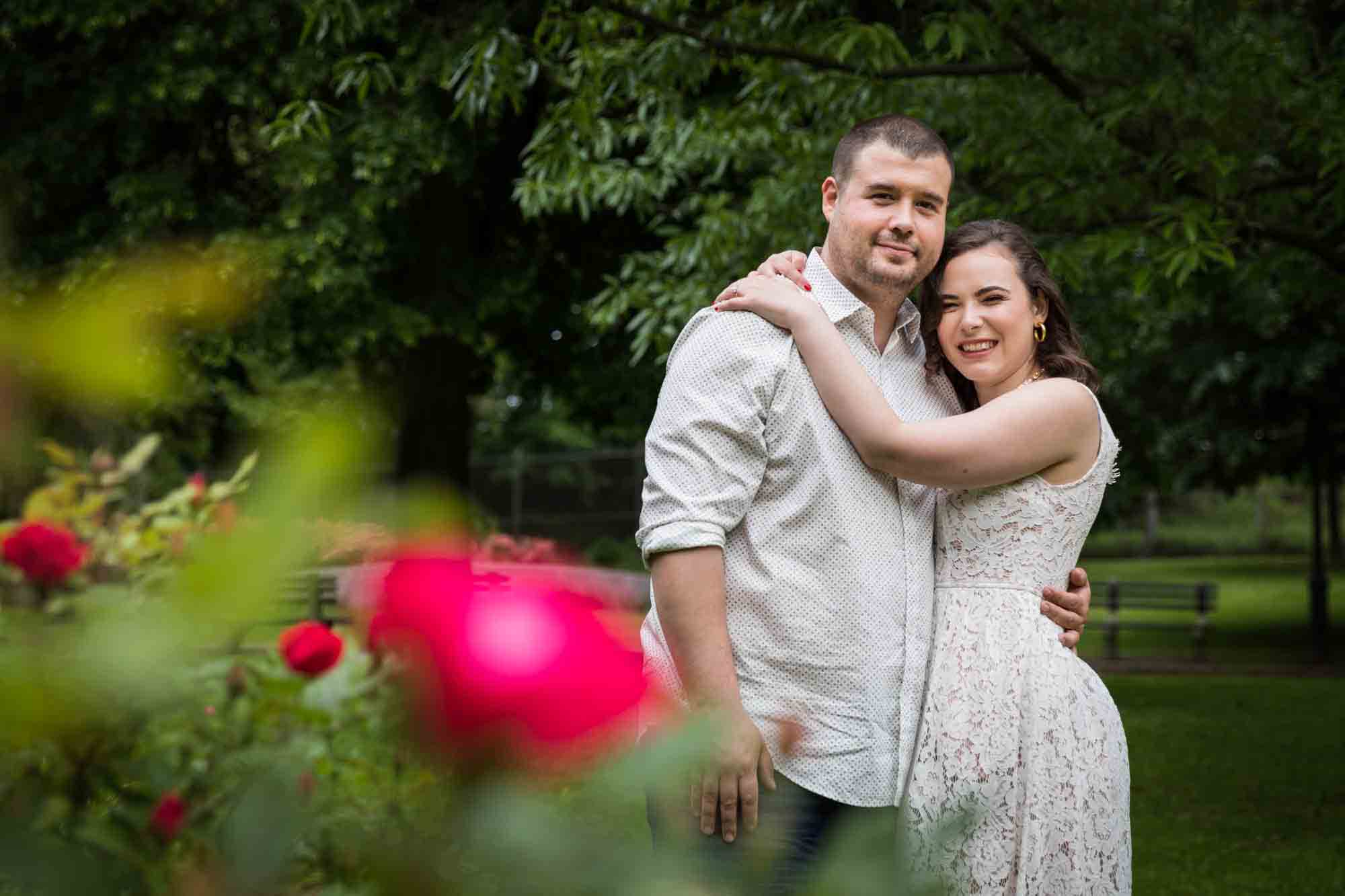 Couple hugging in front of tree for an article on how to recreate your love story in your engagement shoot