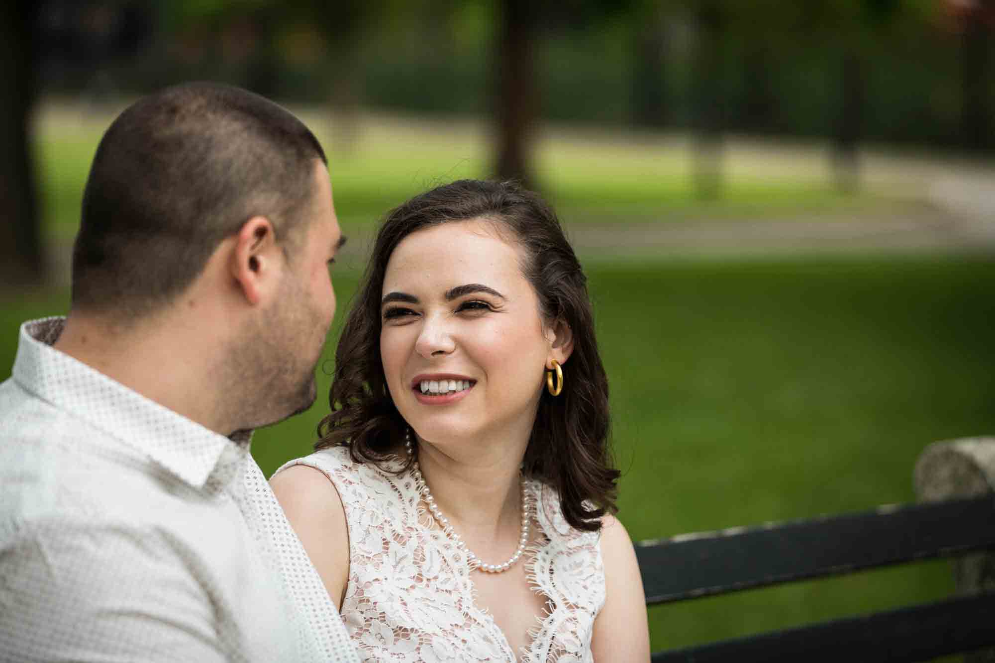 Woman sitting on bench looking at man during a Dyker Heights engagement shoot