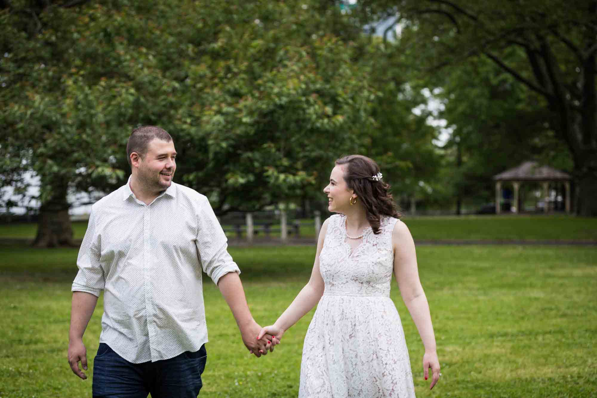 Couple holding hands walking through park for an article on how to recreate your love story in your engagement shoot