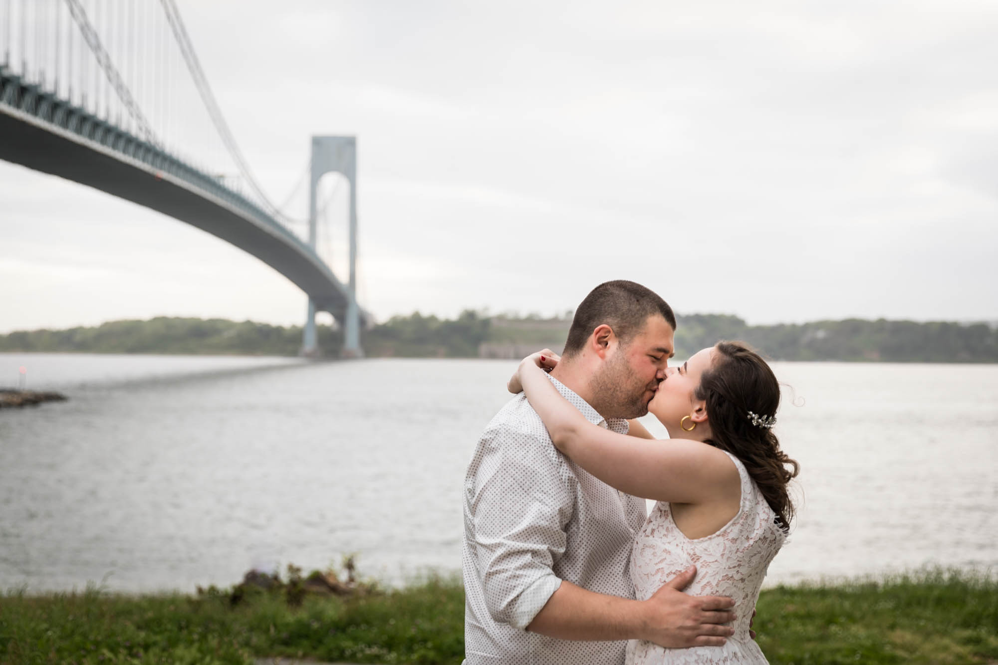 Couple kissing in front of Verrazano Bridge during a Dyker Heights engagement shoot