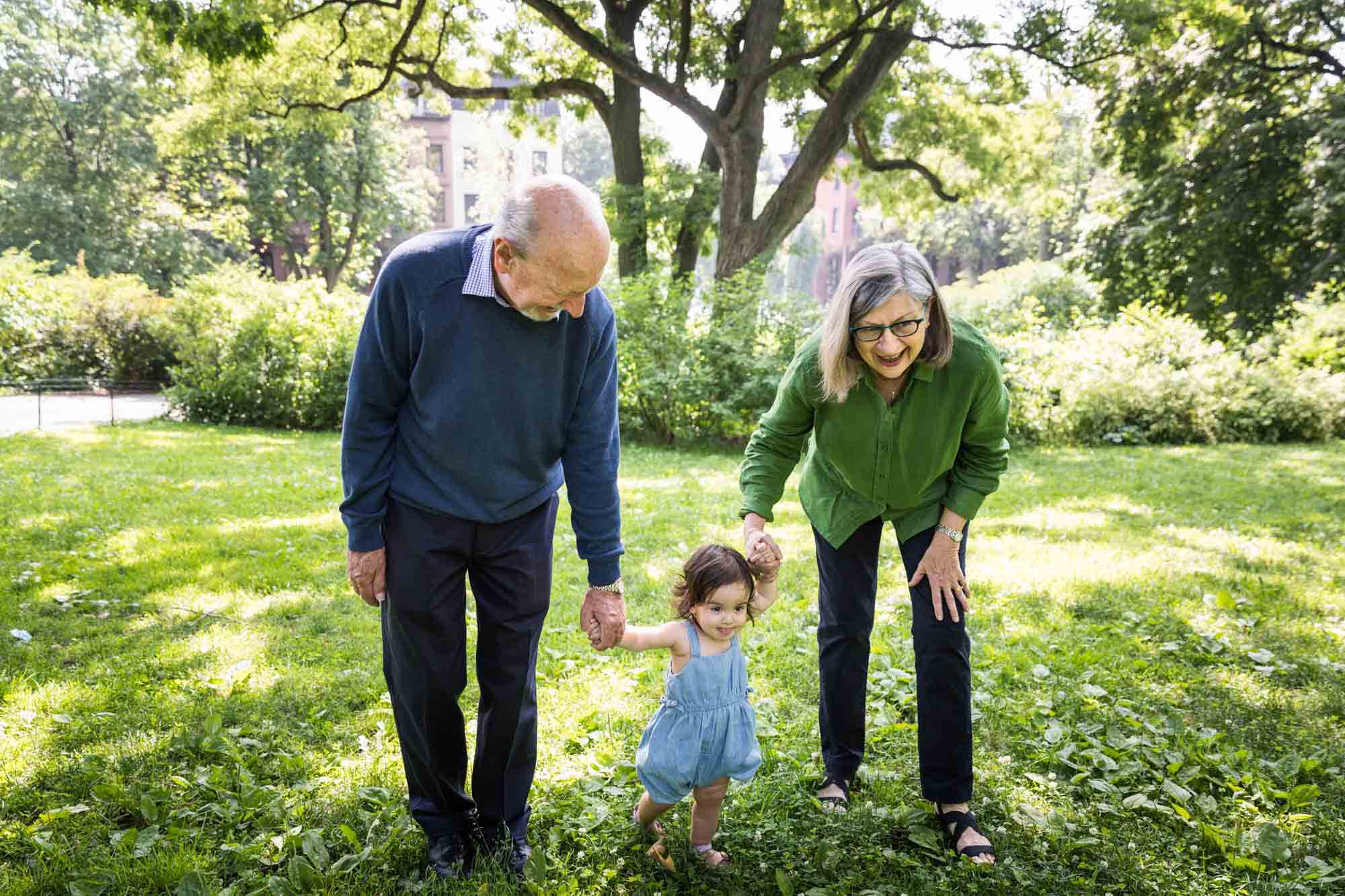 Grandparents walking with toddler during a Fort Greene Park family portrait