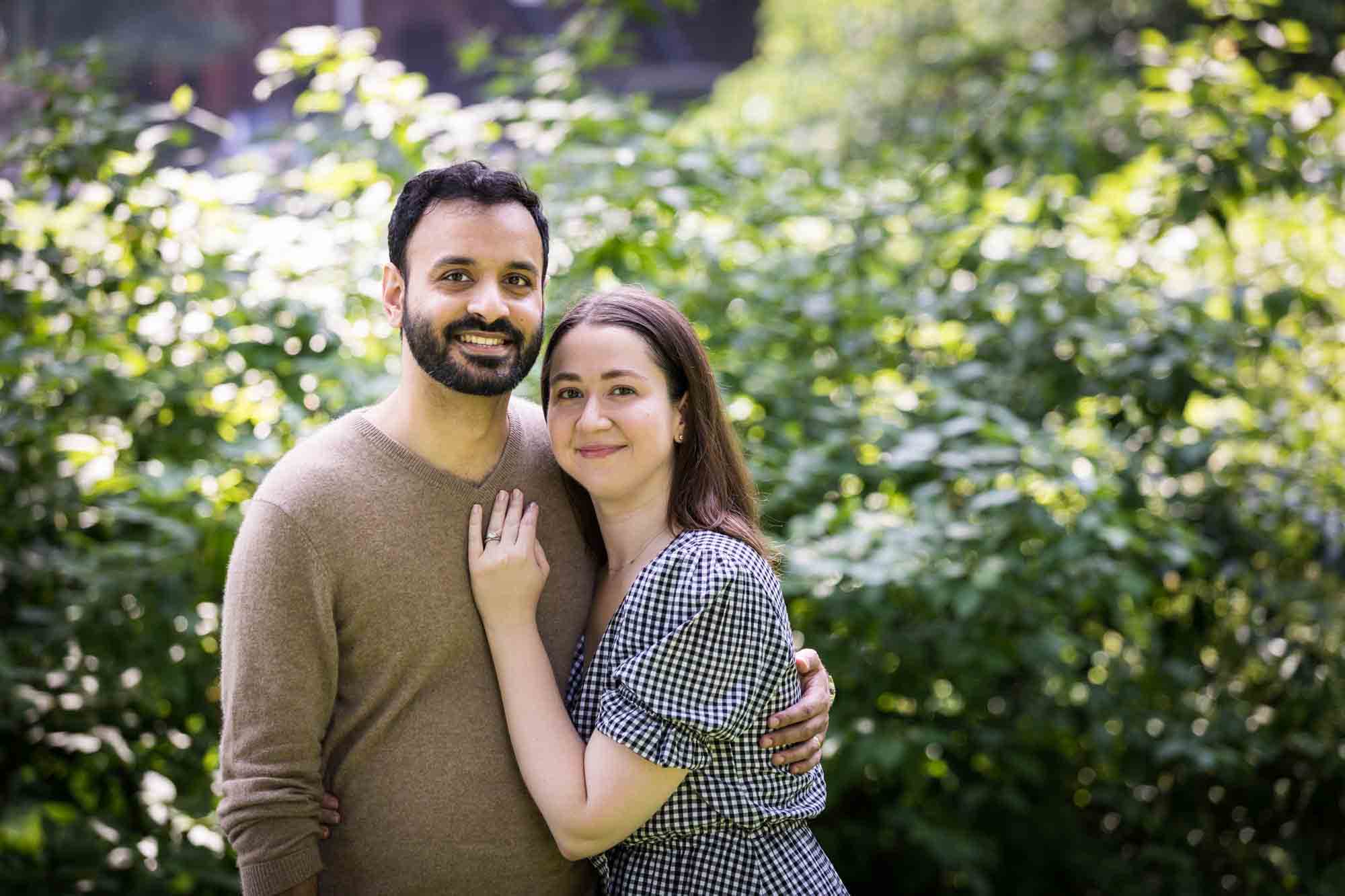 Couple hugging with woman's hand on man's chest during a Fort Greene Park family portrait