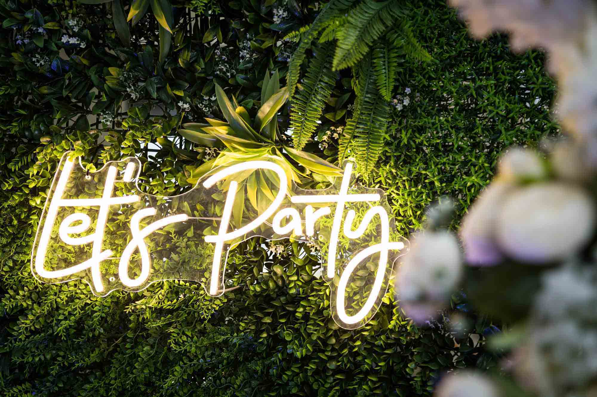 Neon sign saying 'Let's Party' for Loft Story wedding