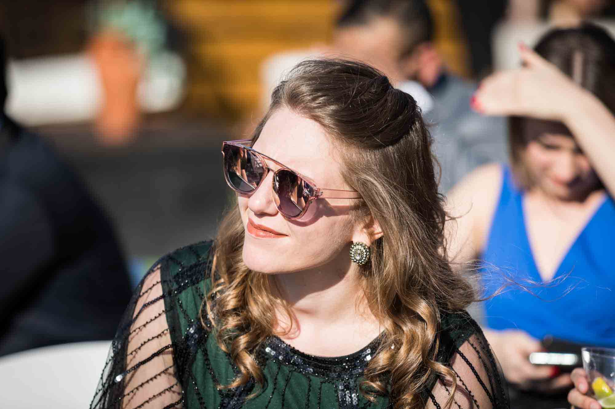 Female guest wearing sunglasses for article on wedding reception game ideas