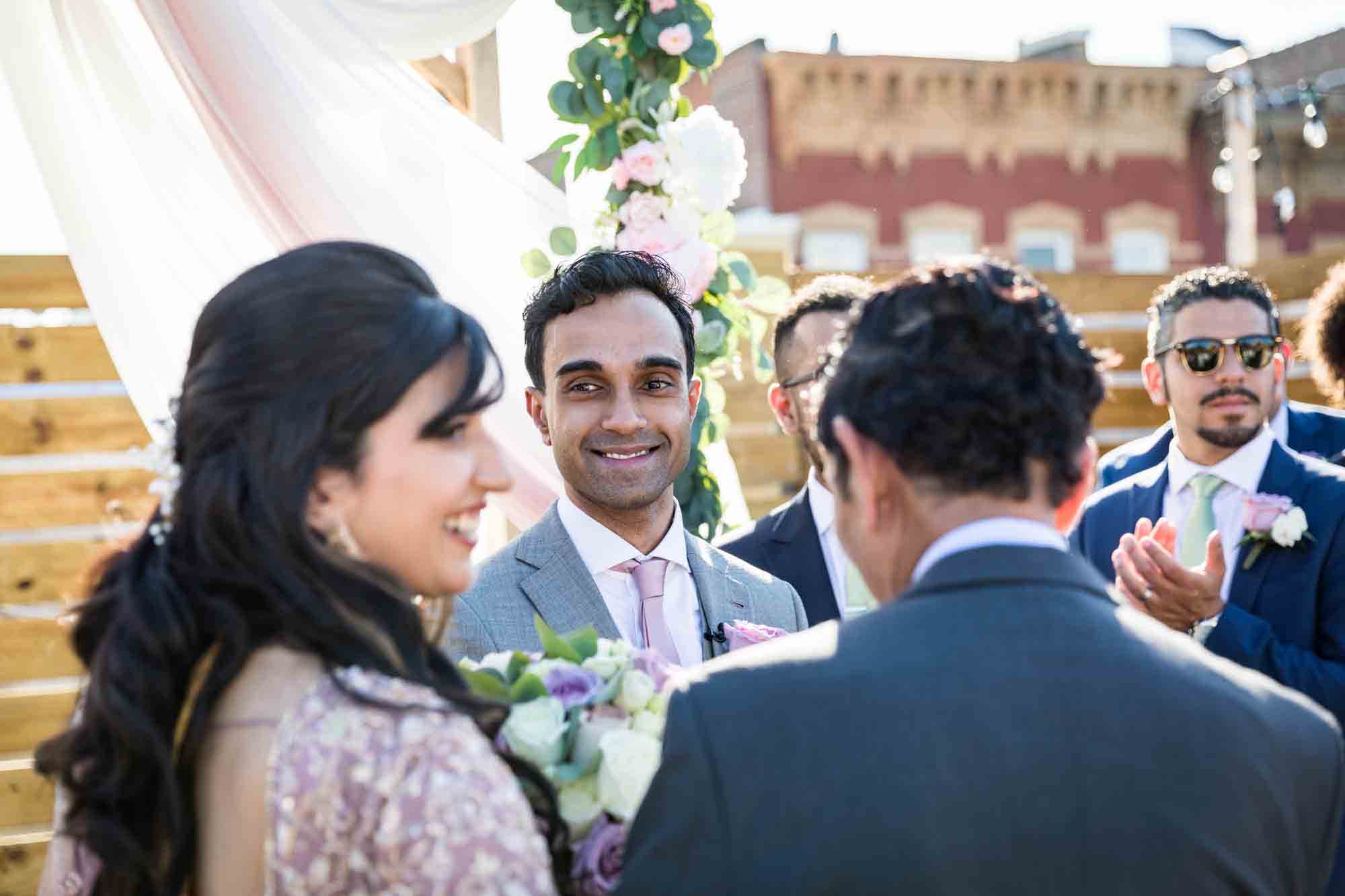 Groom looking at bride during ceremony for article on wedding reception game ideas