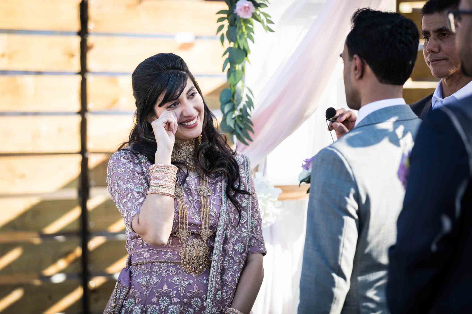 Indian bride wiping away tear during ceremony for article on wedding reception game ideas