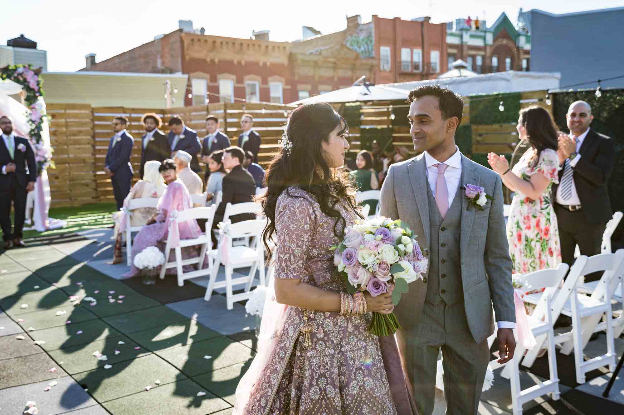 Bride and groom looking at each other at end of aisle after ceremony 