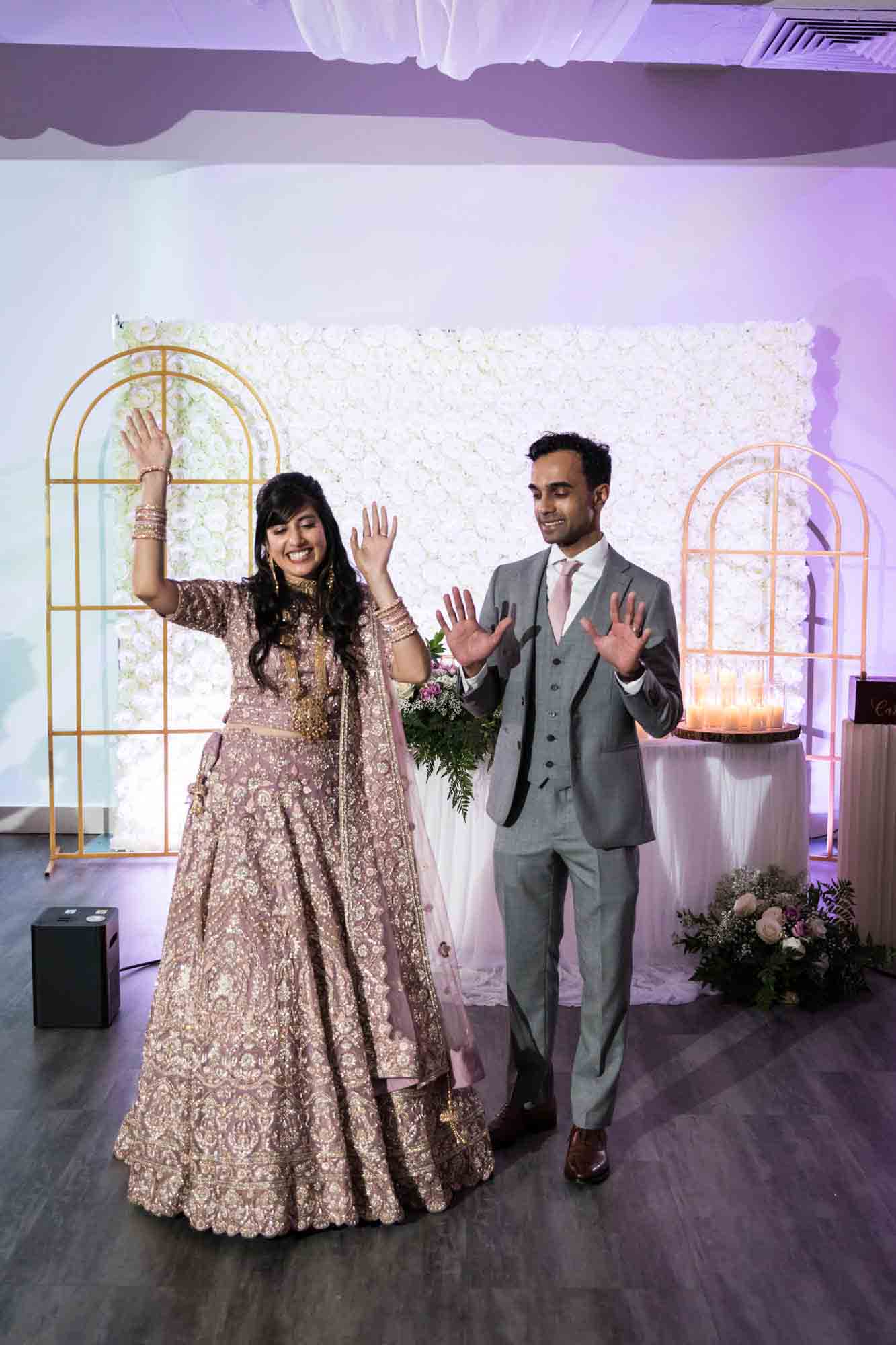 Bride and groom lifting hands in air at reception at a Loft Story wedding