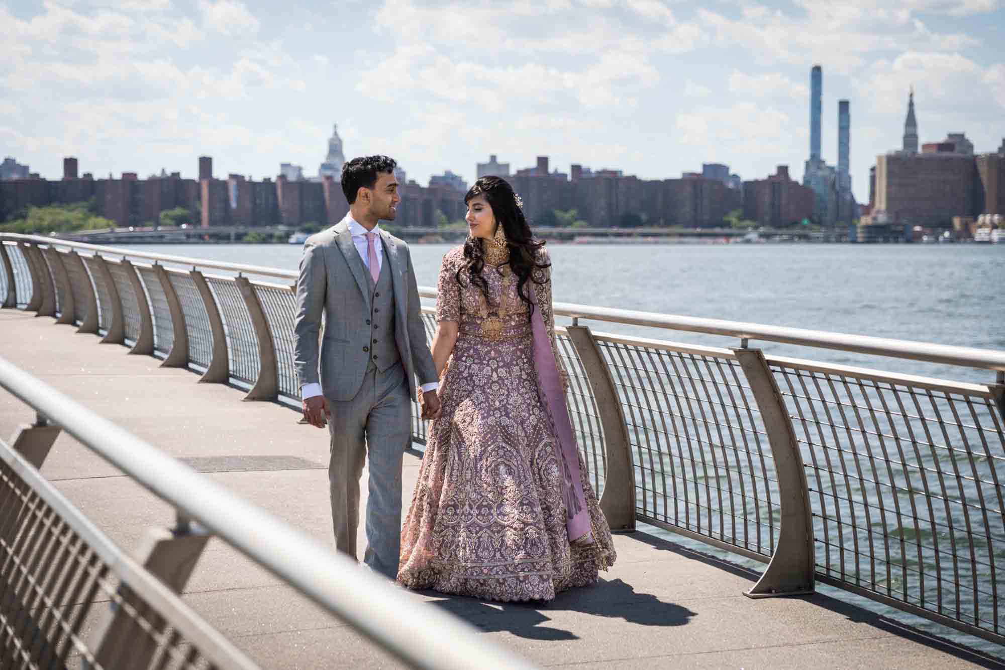 Indian bride and groom walking down dock at WNYC Transmitter Park for article on wedding reception game ideas