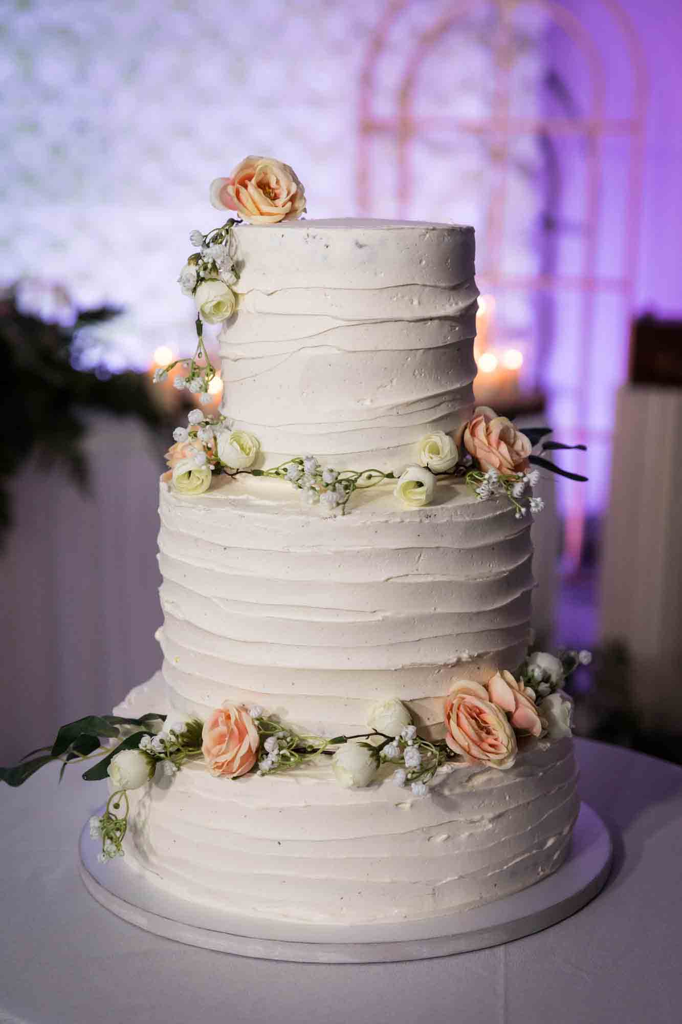 White wedding cake with pink flowers at a Loft Story wedding