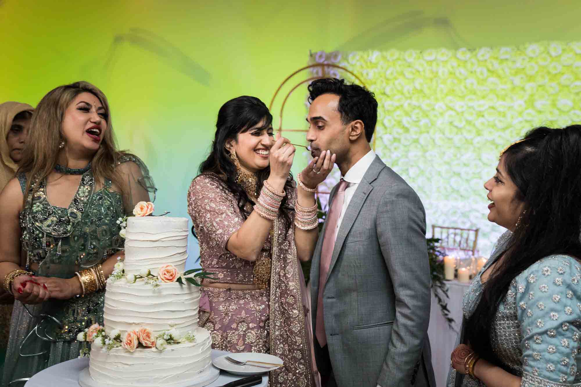 Indian bride feeding cake to groom at a Loft Story wedding