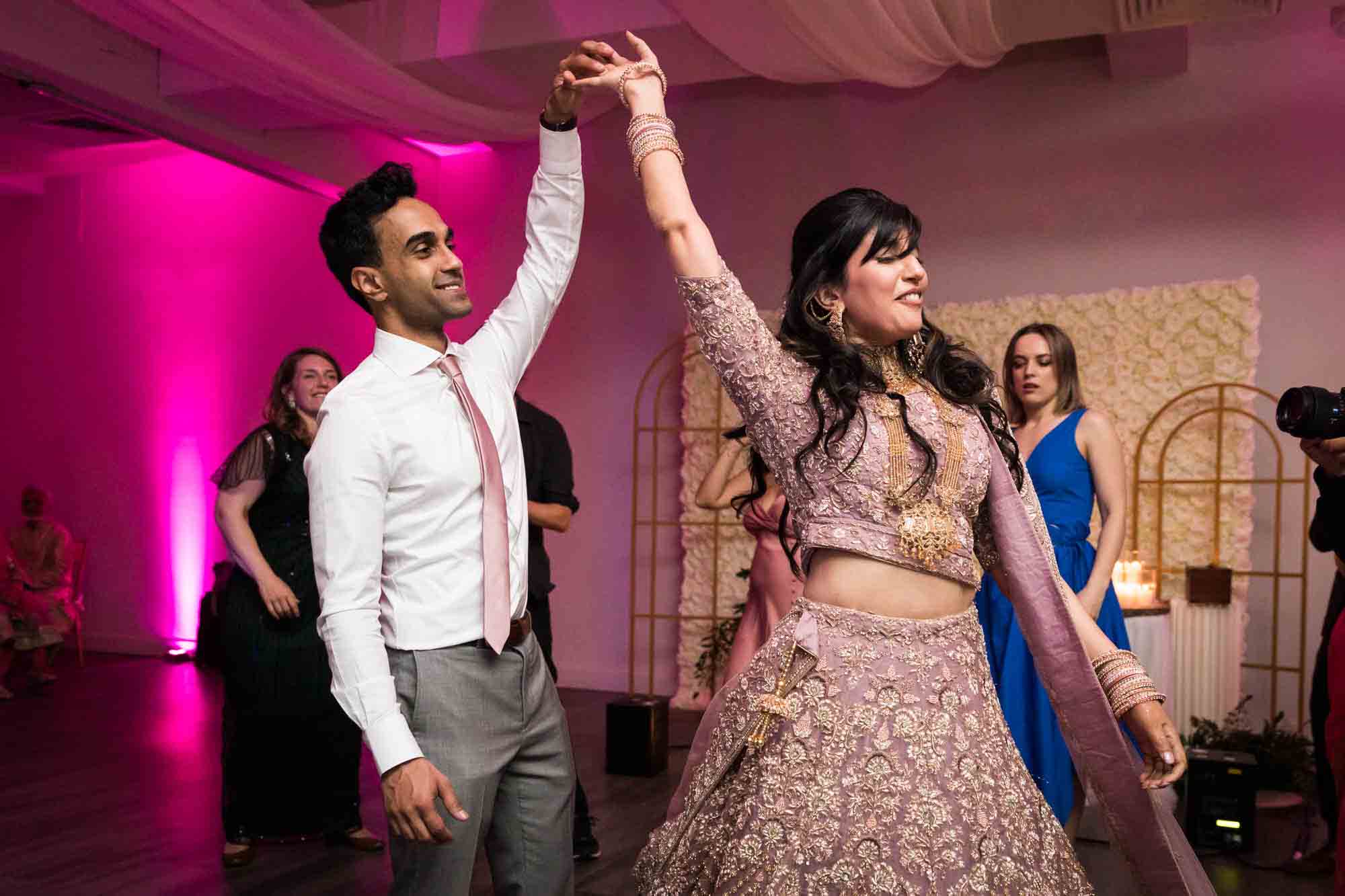 Bride and groom holding hands overhead for article on wedding reception game ideas