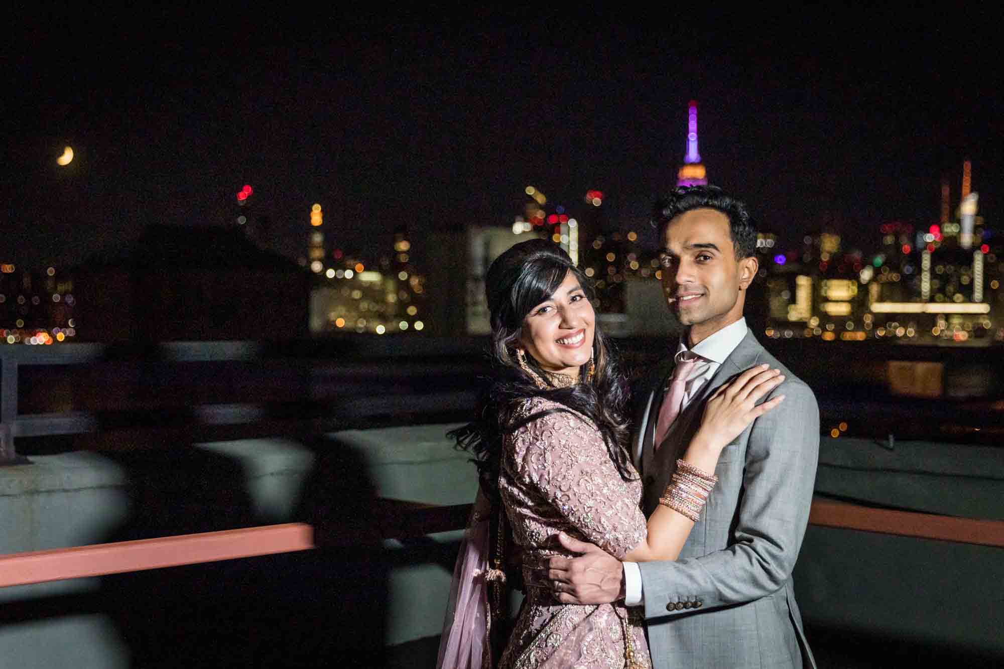 Indian bride and groom on a rooftop at night with NYC skyline in the background at a Loft Story wedding