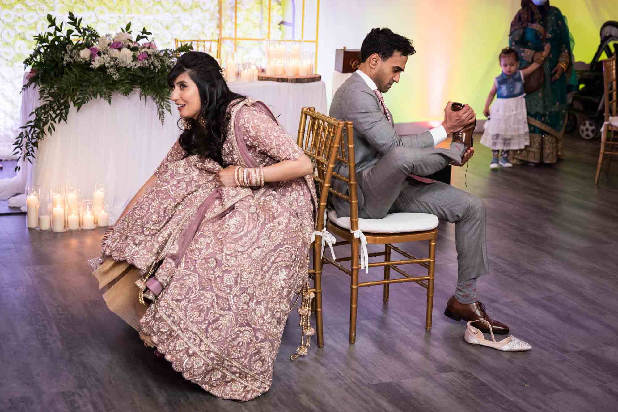 Bride and groom taking off shoes for shoe game for article on wedding reception game ideas