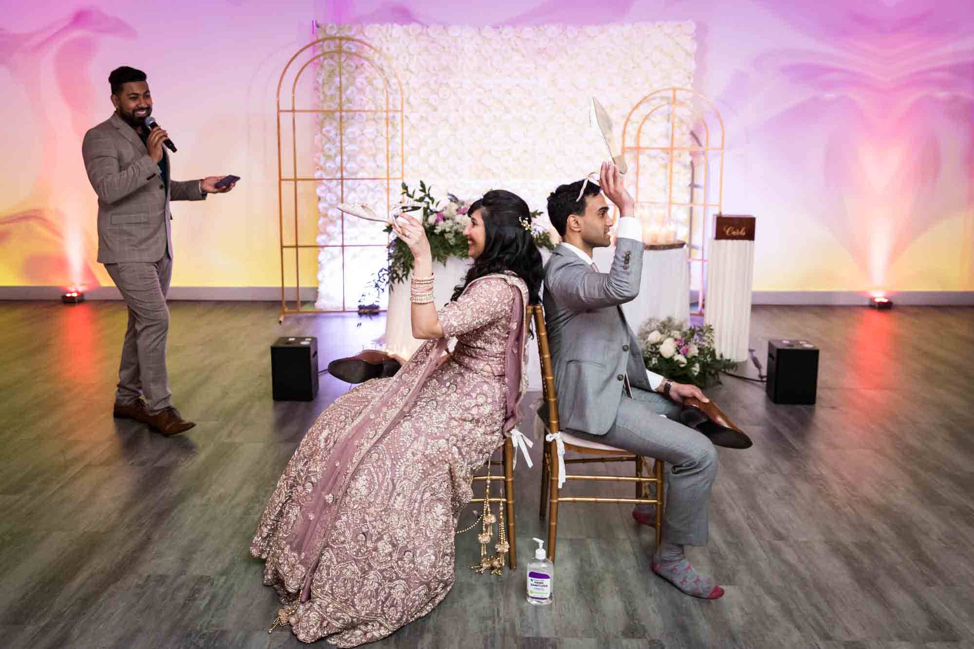 Bride and groom holding up shoes on dance floor for article on wedding reception game ideas