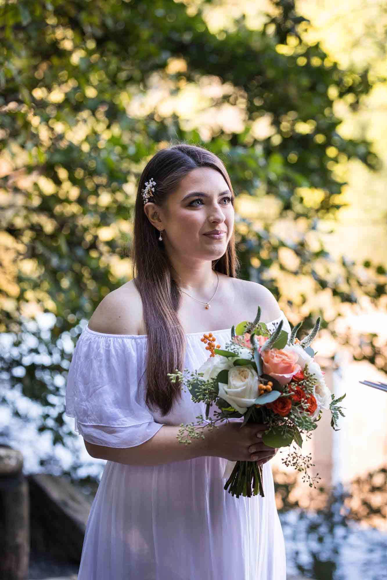 Bride wearing white and holding flower bouquet at Central park elopement