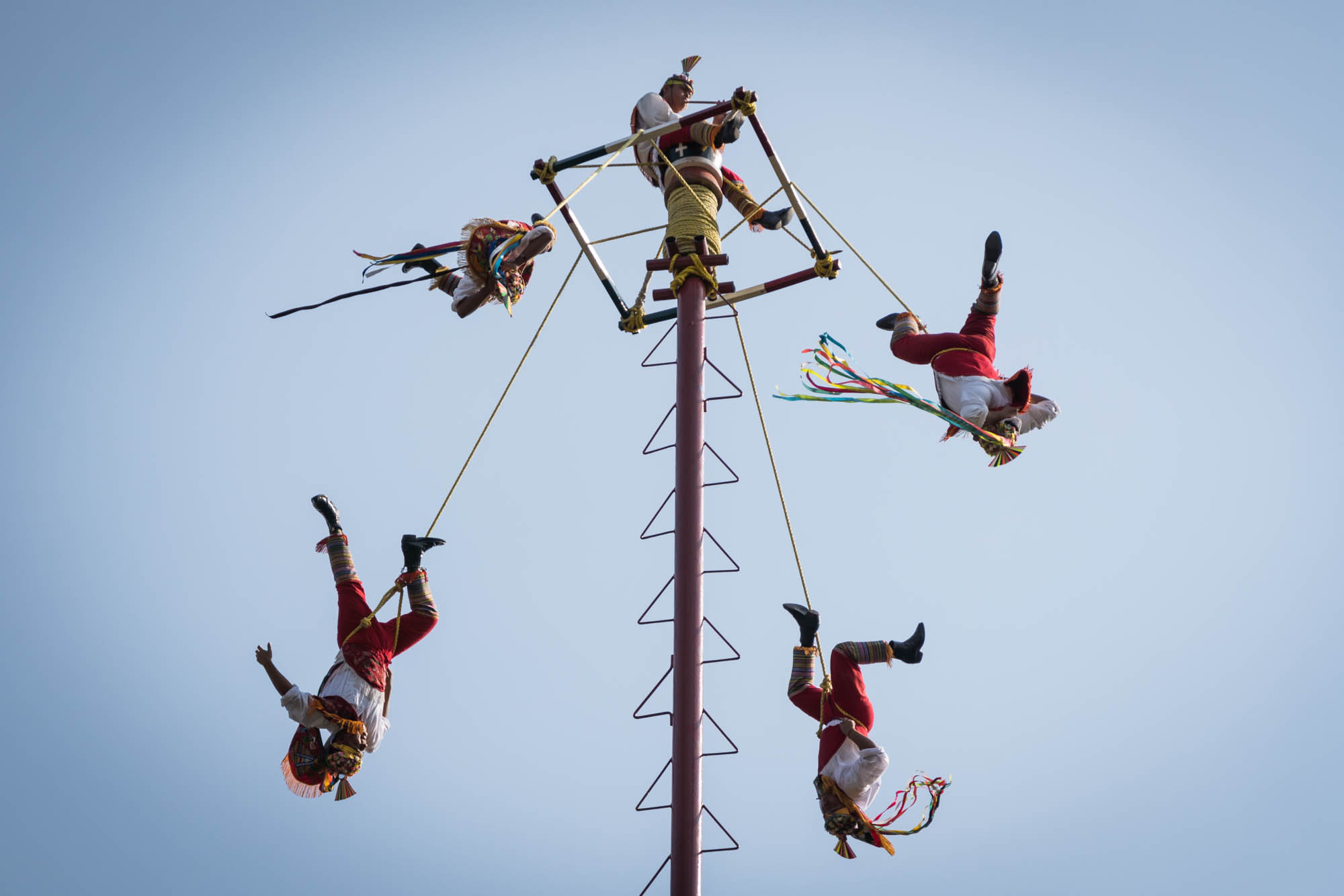 Acrobats flying around a pole outside the anthropological museum in Mexico City