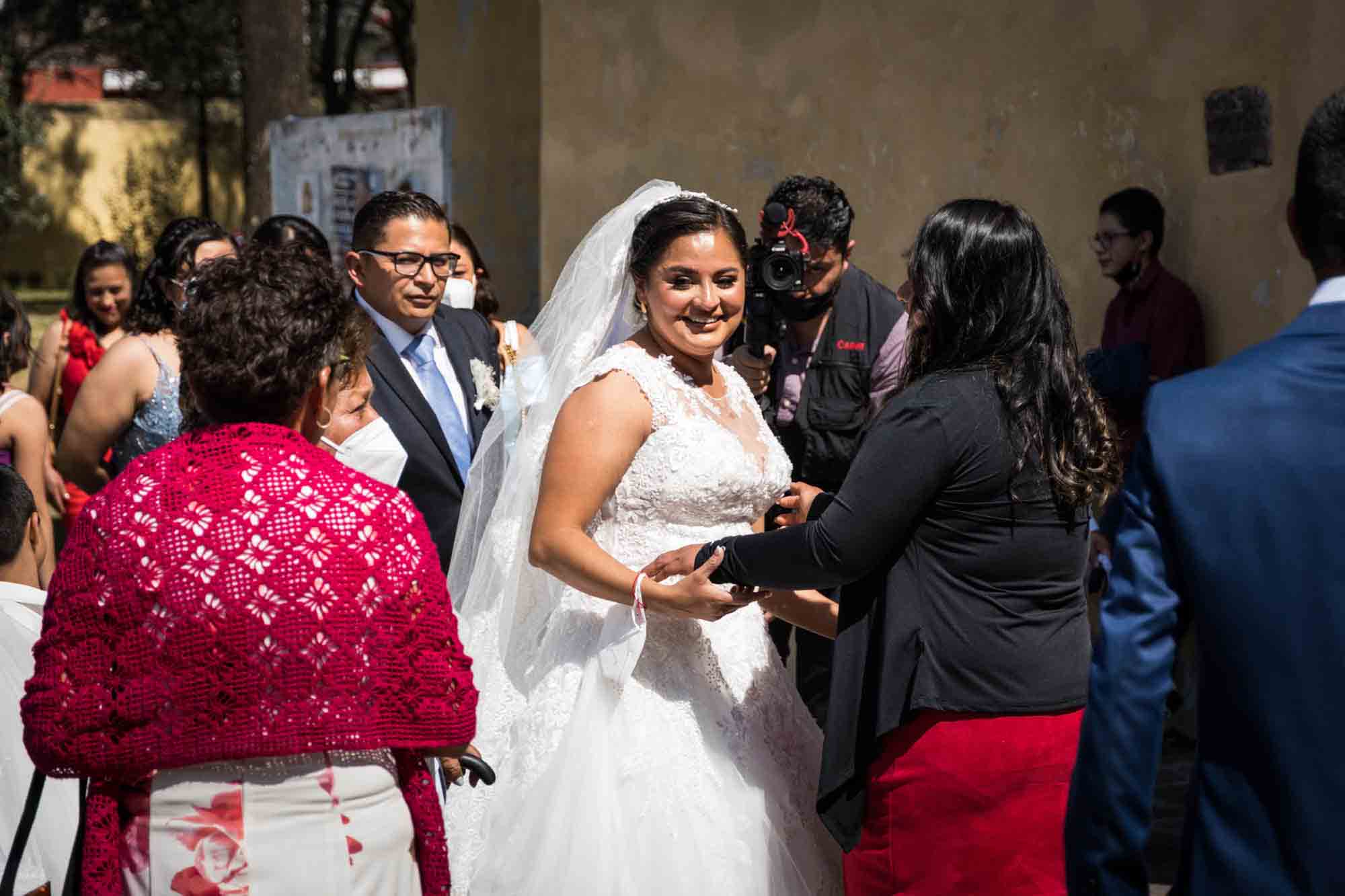 A bride greets her family outside a church in Mexico