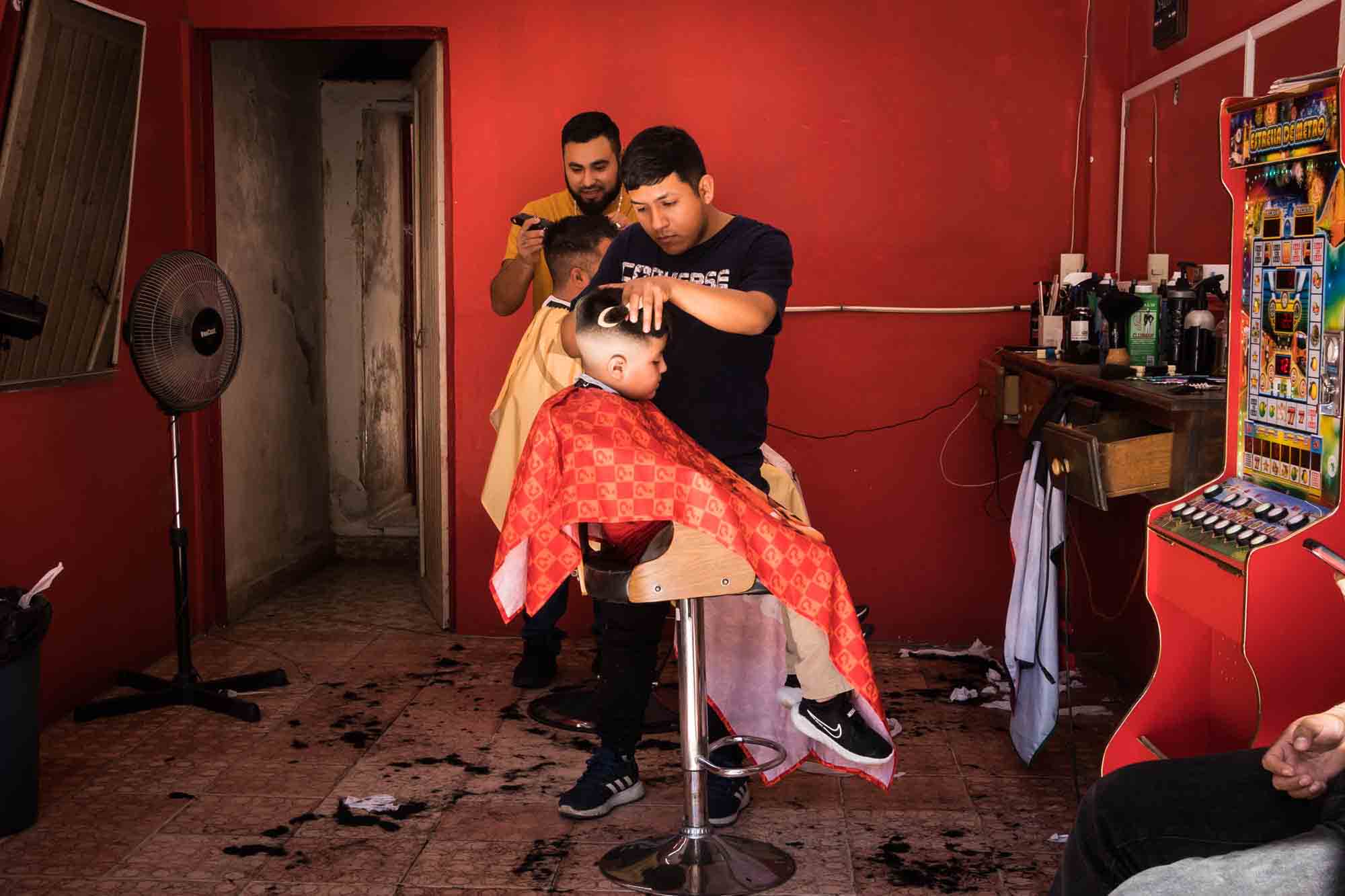 A boy getting a haircut from a barber in Xilitla