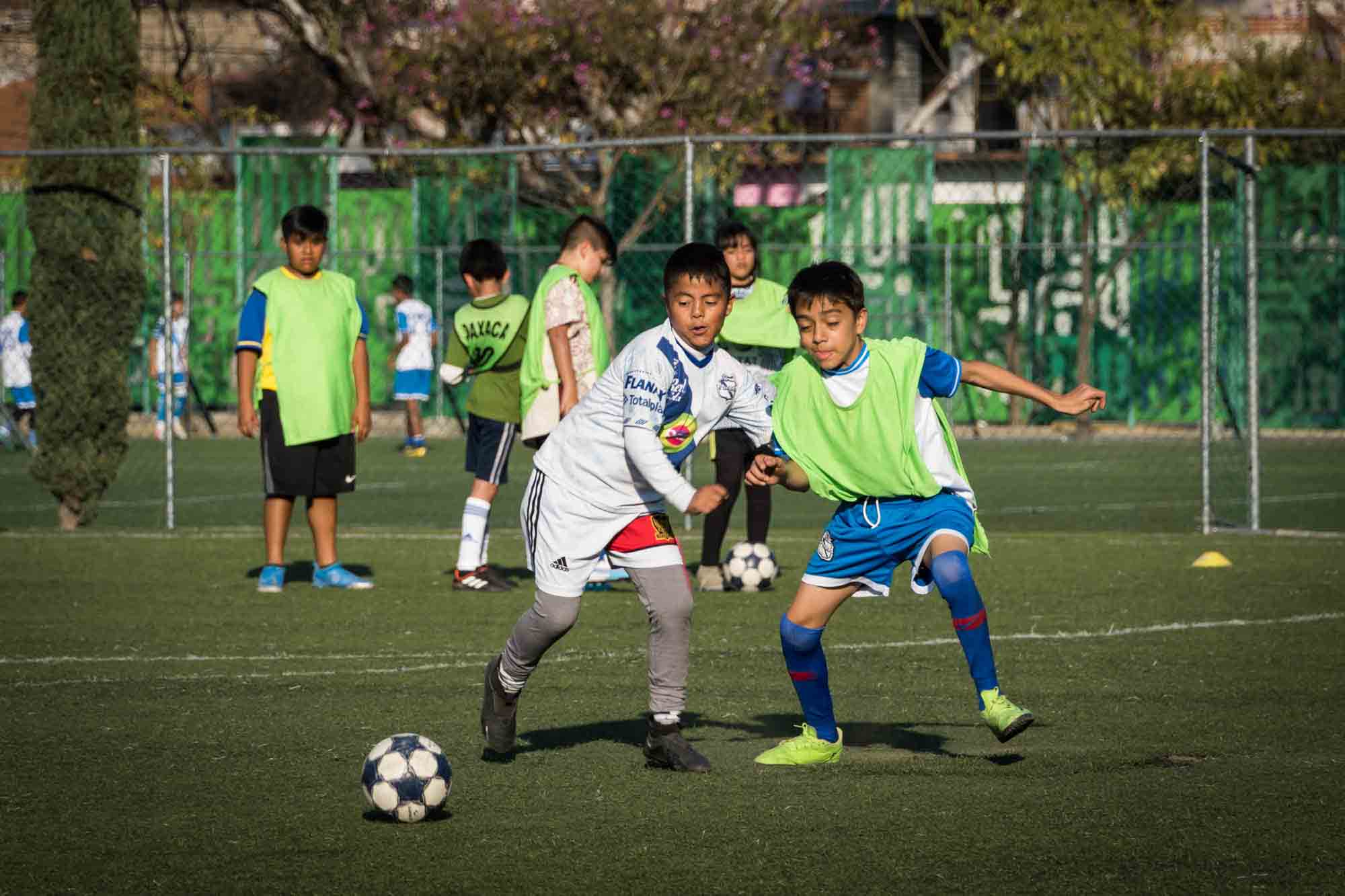 Two boys play soccer on a field in Oaxaca