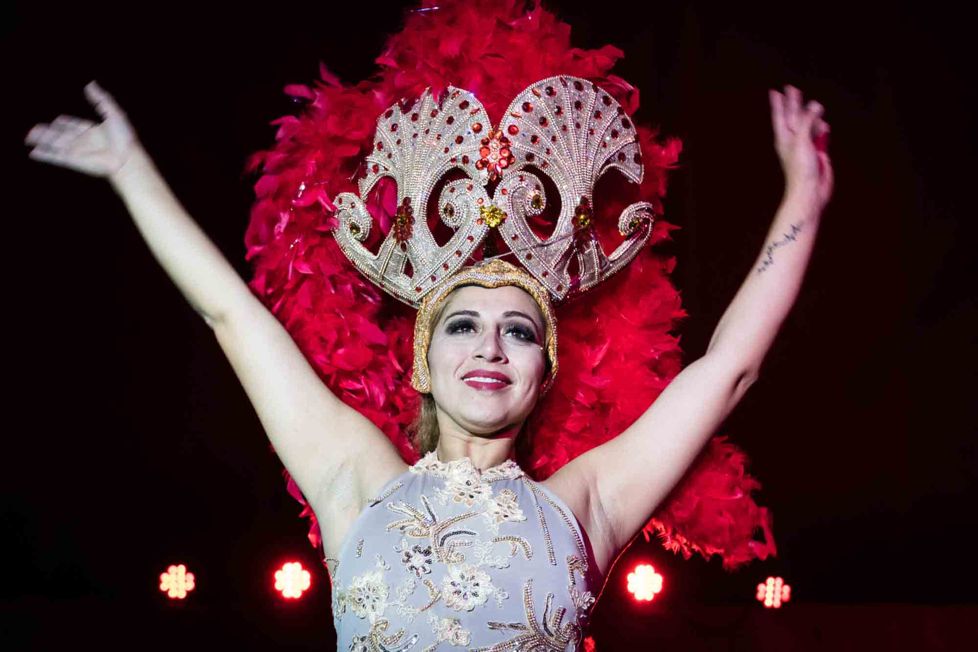 A showgirl wearing a red feather headdress in the Forever Circle performing in Valladolid