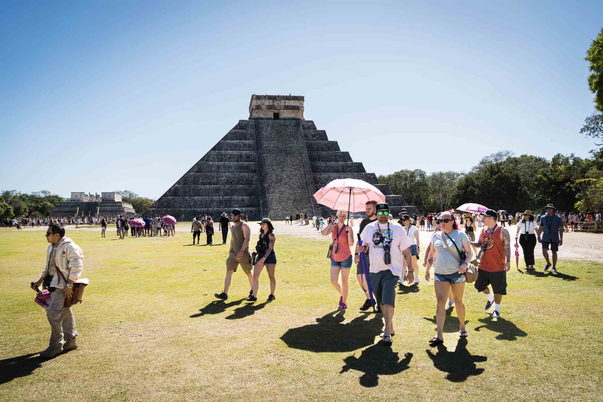 Tourists parading past the pyramids of Chichen Itza