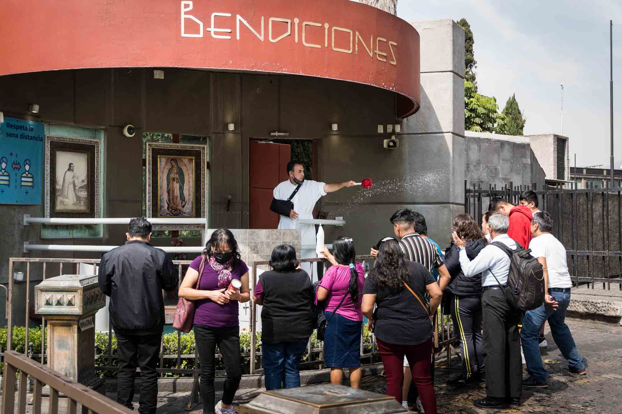 A priest performs a blessing with water on a group of parishoners outside the Basilica of Our Lady of Guadalupe in Mexico City