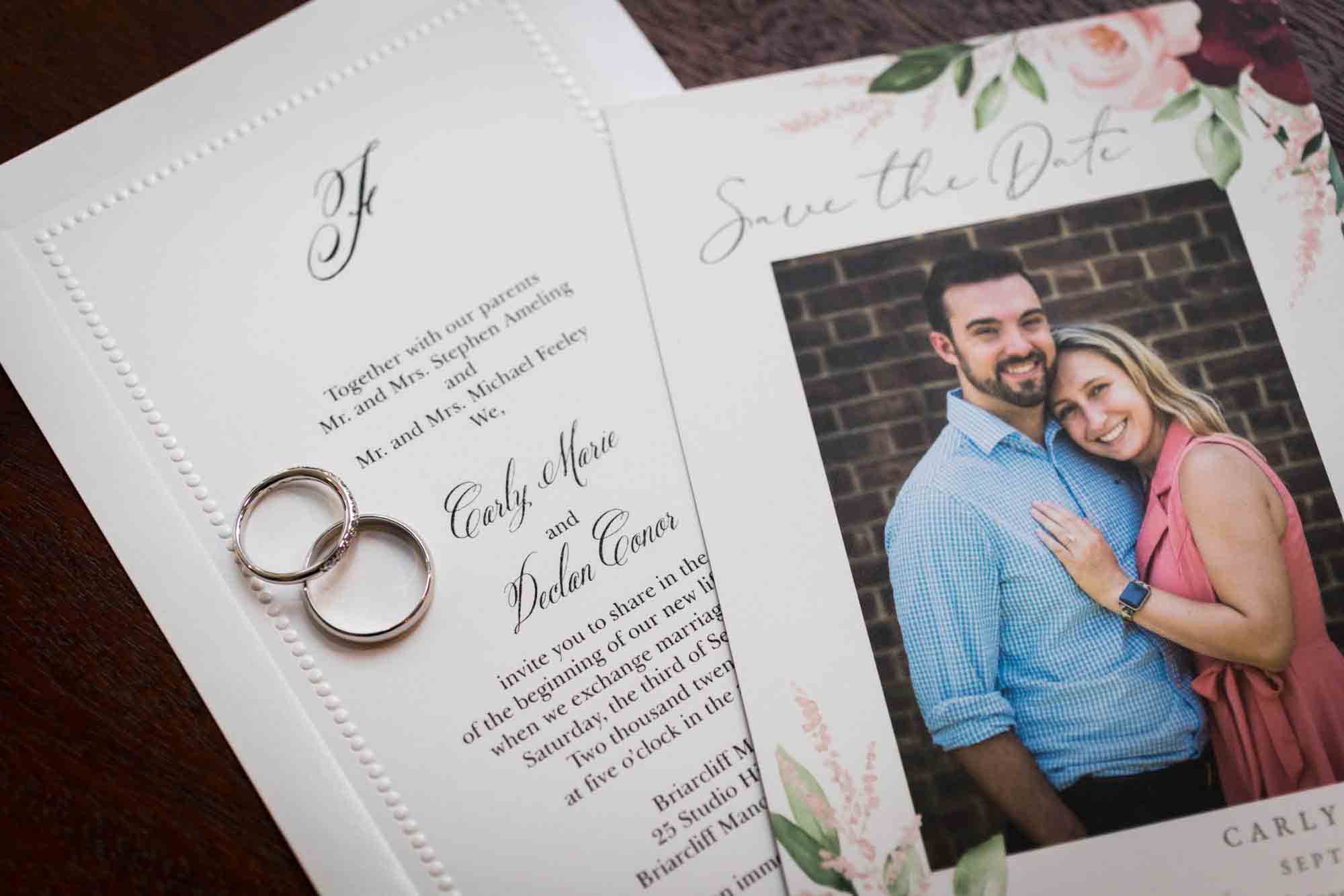 Close up of invitation with photo of bride and groom and two wedding rings