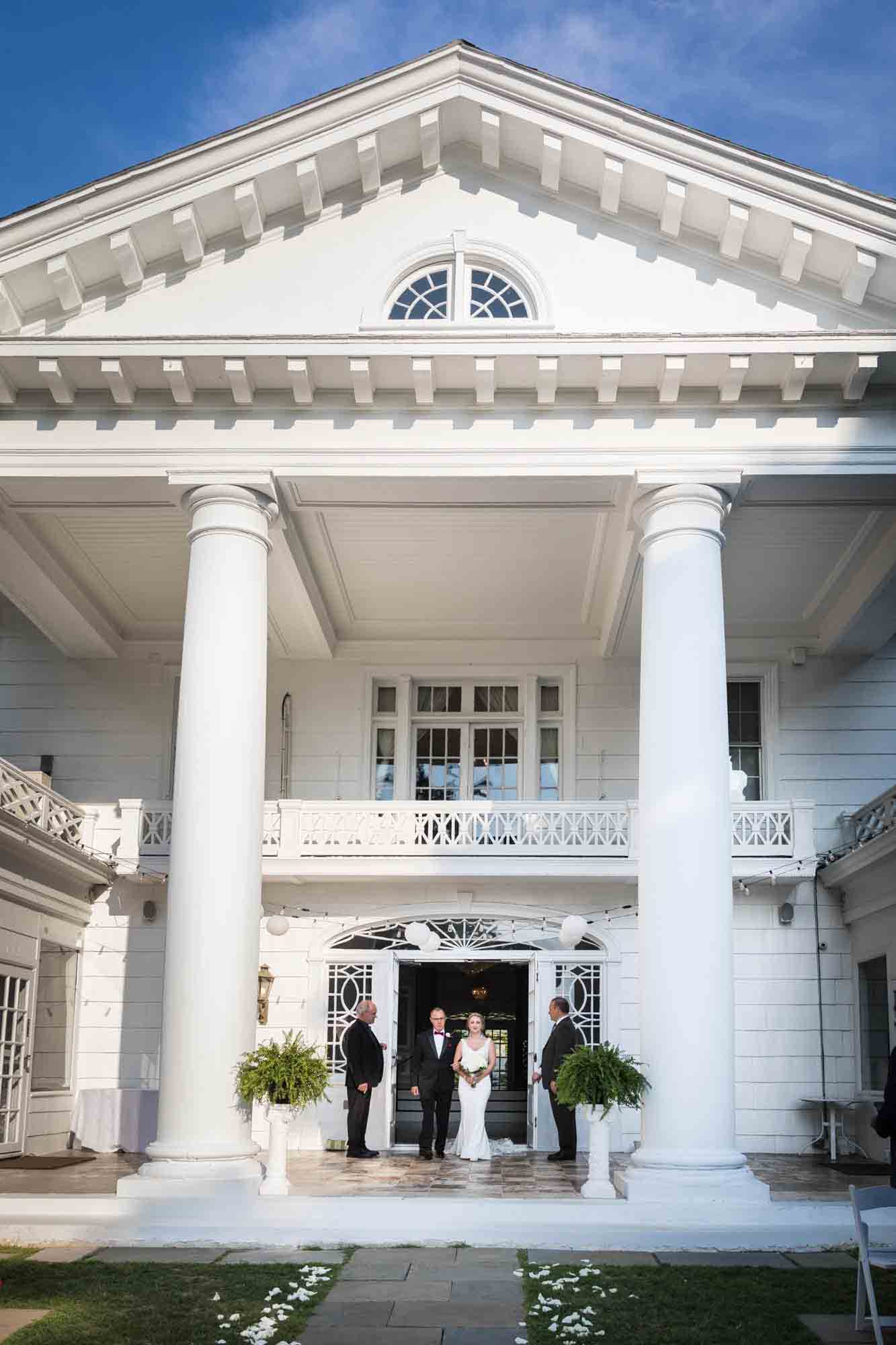Bride and father in front of white historical home with Greek columns at a Briarcliff Manor wedding
