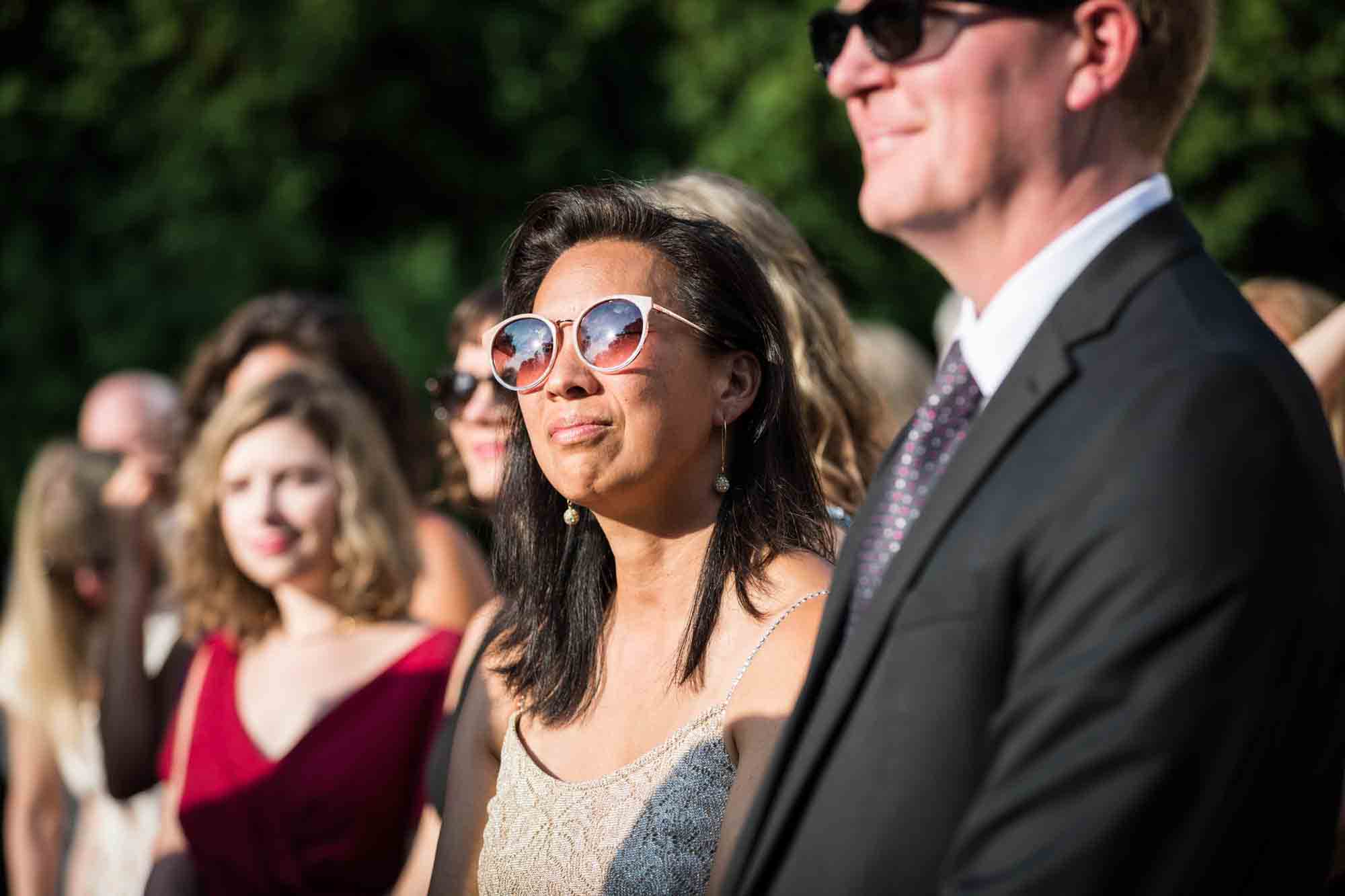 Female guest wearing sunglasses at ceremony at a Briarcliff Manor wedding