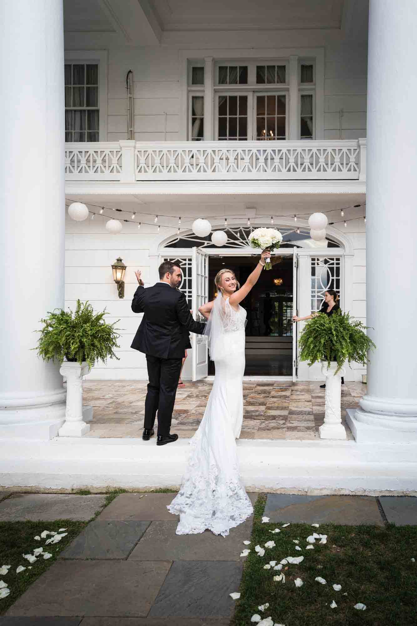 Bride and groom fist pumping and looking backwards after ceremony at a Briarcliff Manor wedding