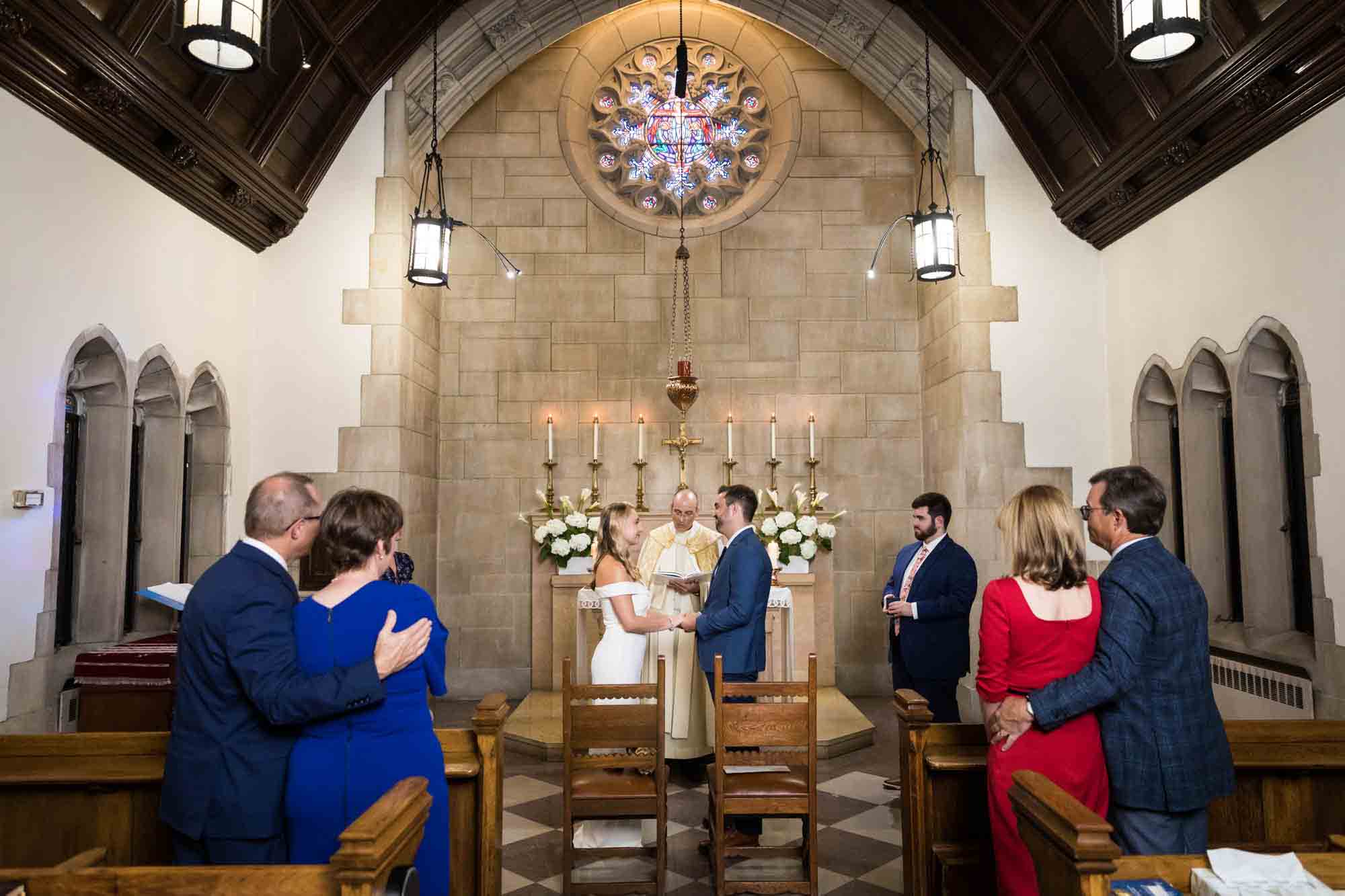 Bride and groom saying vows in small chapel of St. Paul Apostle Church