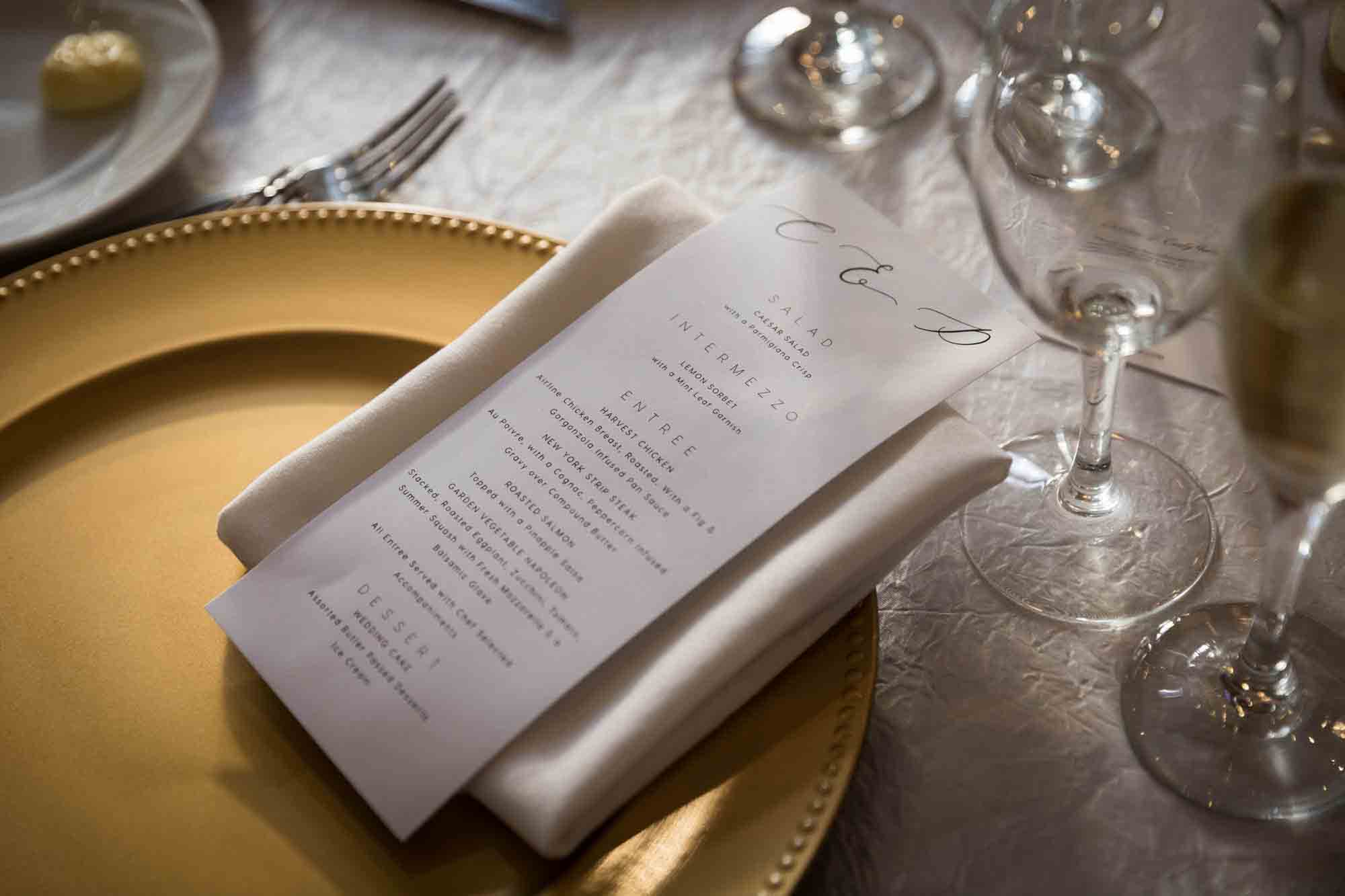 White paper menu on napkin and gold charger at a Briarcliff Manor wedding