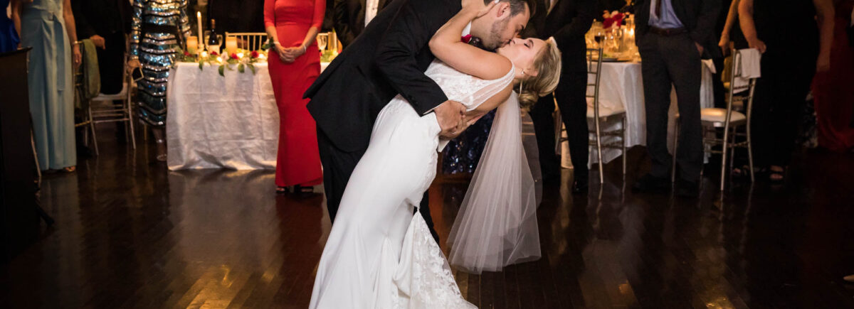 Groom kissing bride with dramatic dip during first dance at a Briarcliff Manor wedding