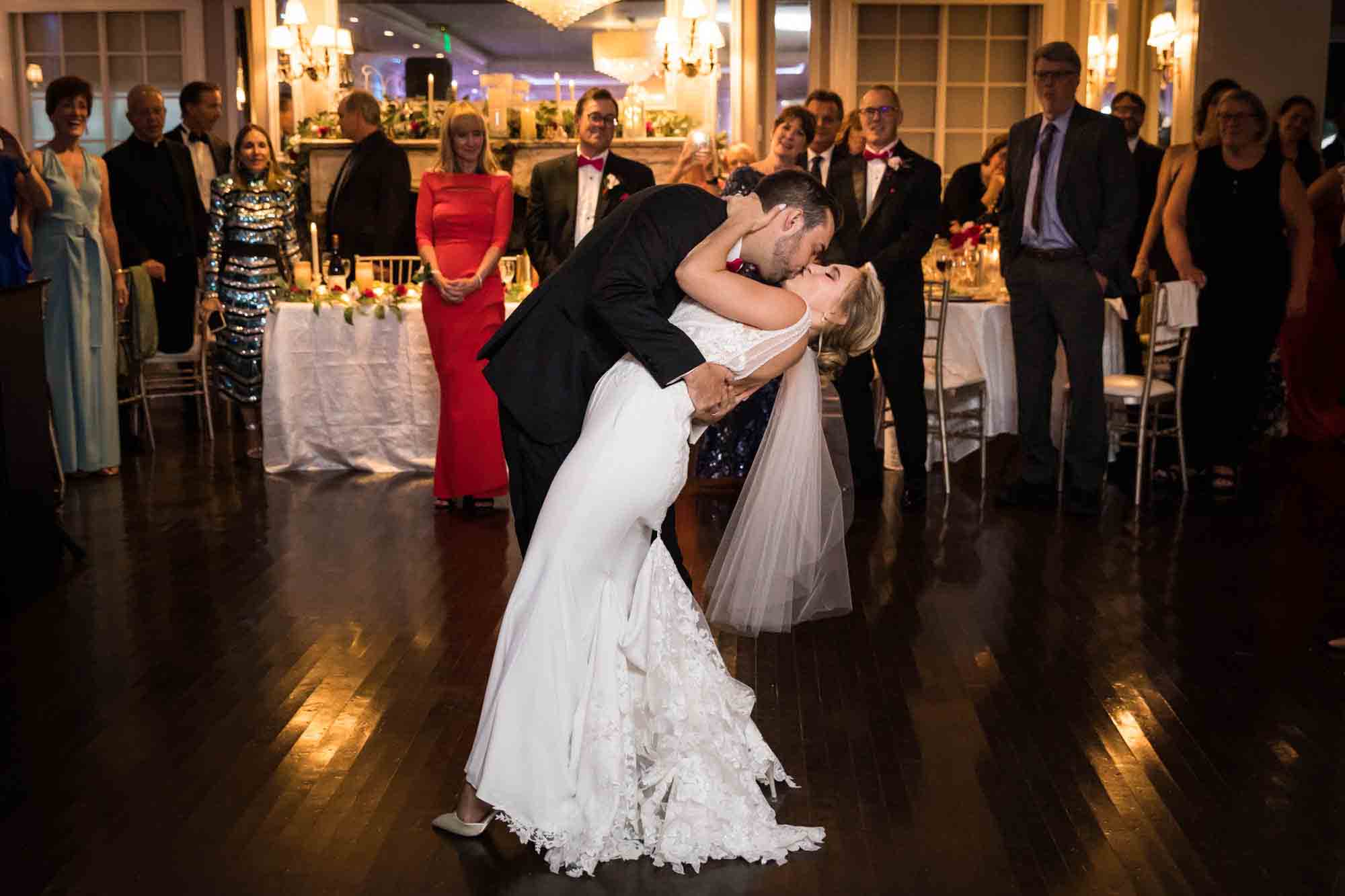 Groom kissing bride with dramatic dip during first dance at a Briarcliff Manor wedding