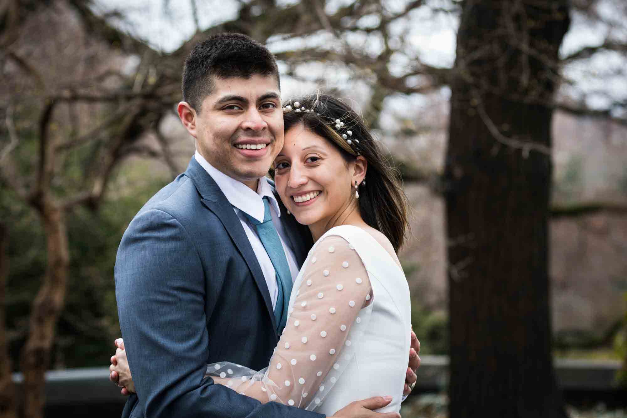A bride and groom hug during a Fort Tryon Park wedding