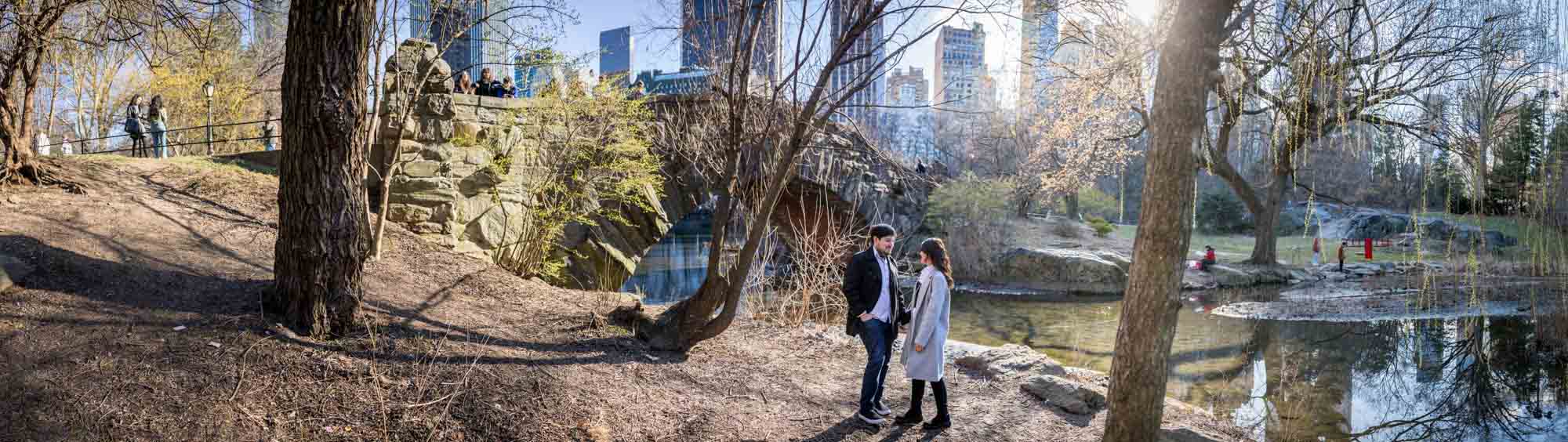 Panorama of couple in front of Gapstow Bridge during a Central Park surprise proposal