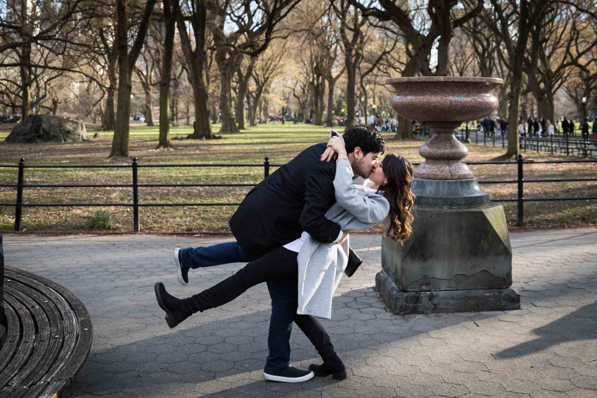 Couple kissing while doing dip in park during a Central Park surprise proposal
