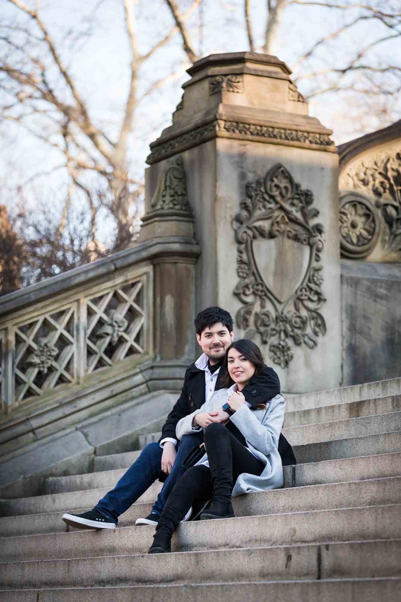 Couple sitting together on Bethesda Terrace staircase after a NYC surprise proposal