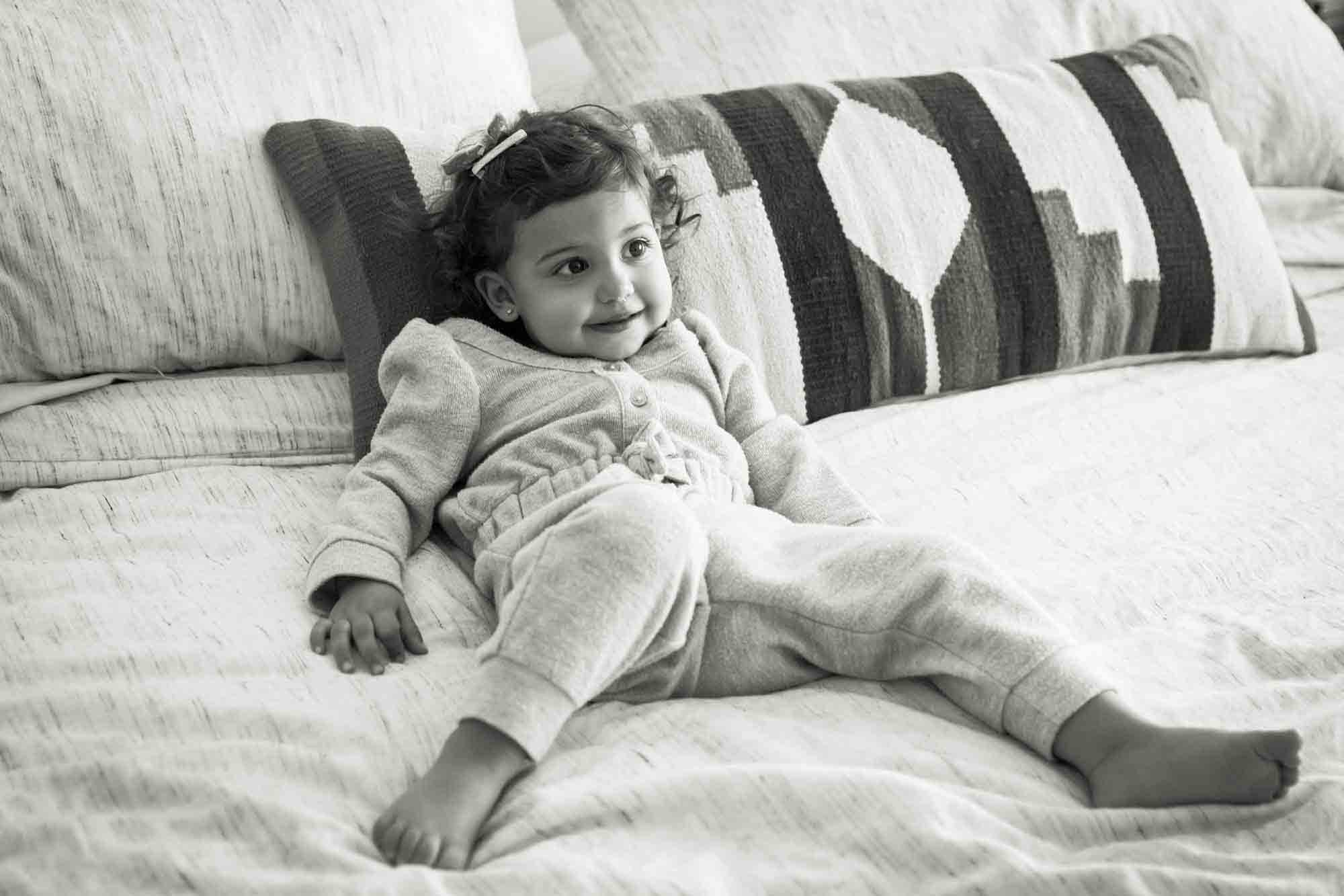 Little girl laying on bed during a Manhattan family portrait session