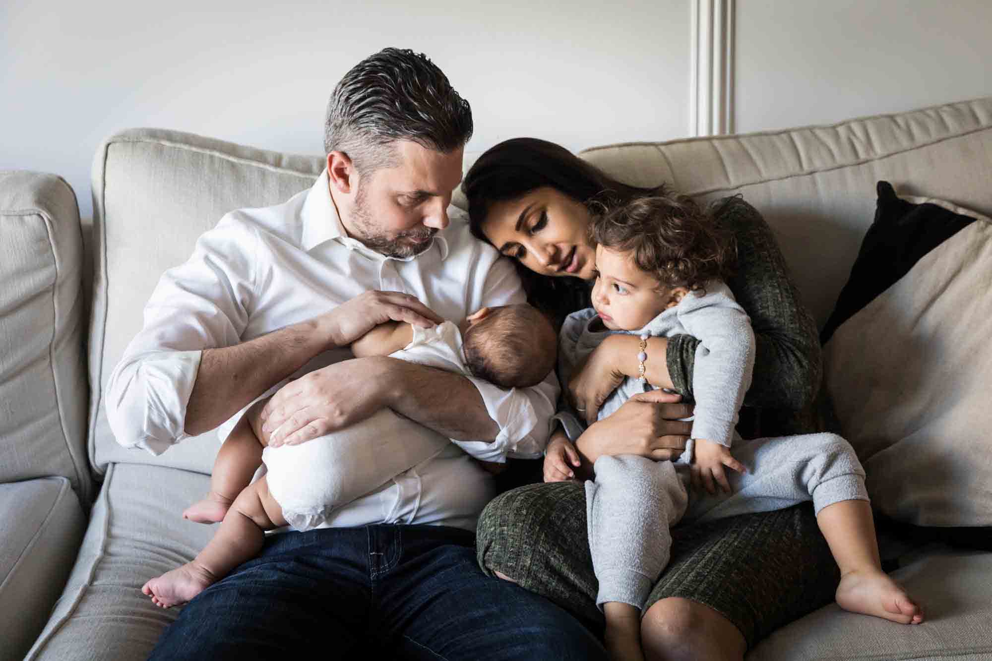 Manhattan family portrait session of parents and two little children sitting on couch