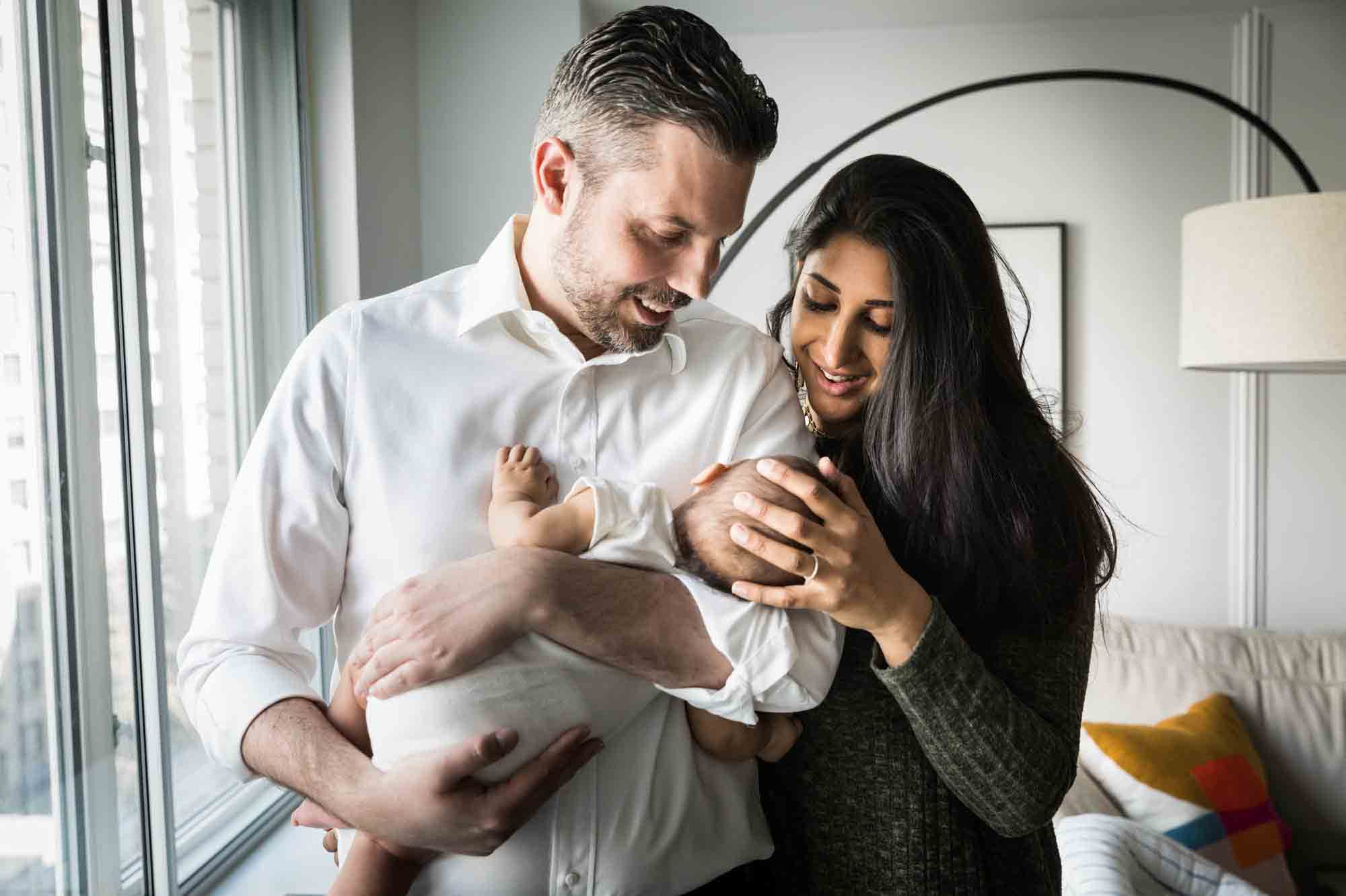 Parents looking down at newborn during a NYC family portrait session